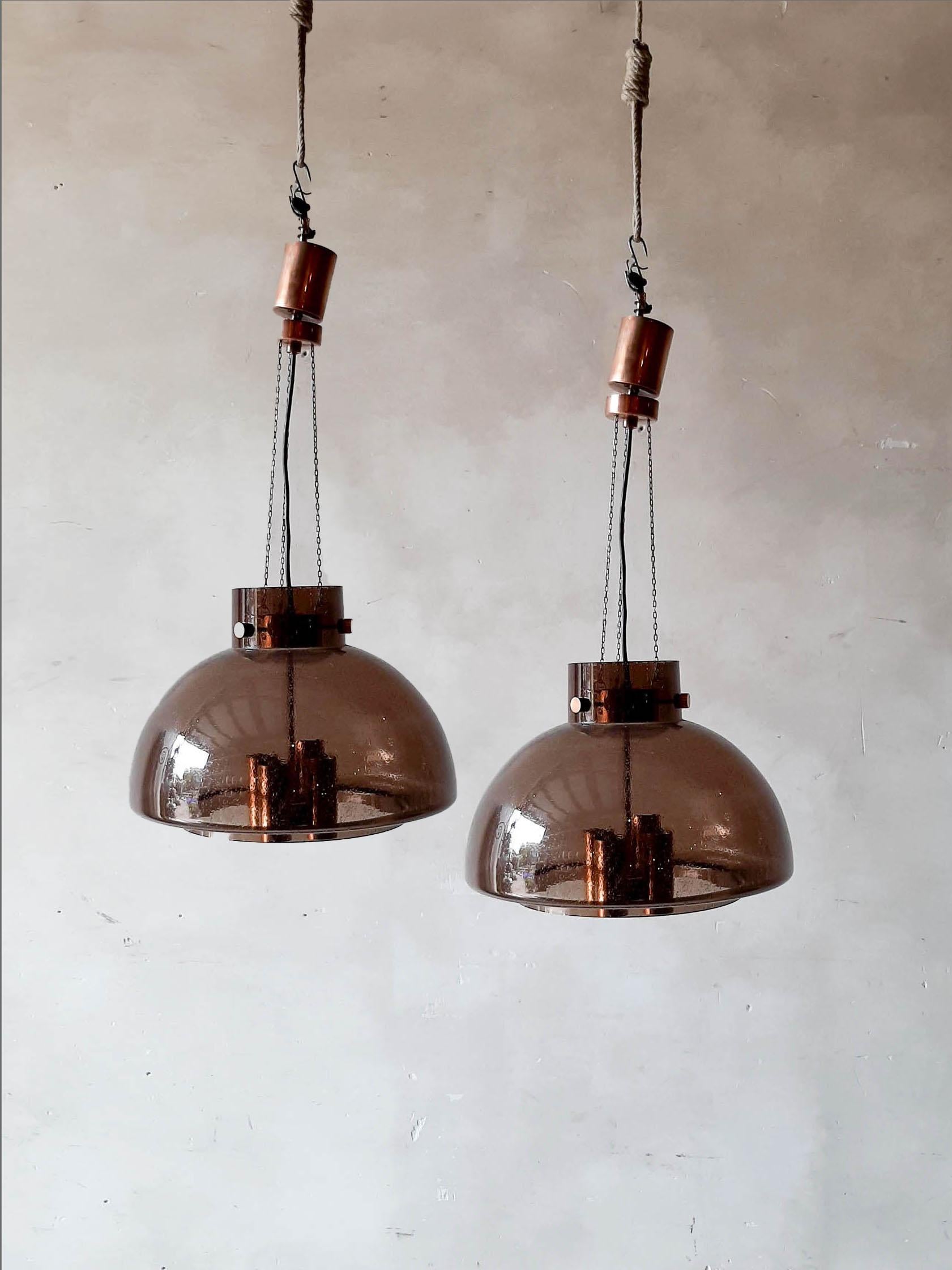 Pair of vintage brown glass pendant lamps from Glashütte Limburg by Herbert Proft, Germany 1970-79.
A pair of hand blown pendant light fixtures, the brown glass has small air bubbles in it, what gives a nice diffuse light effect and a nice pattern