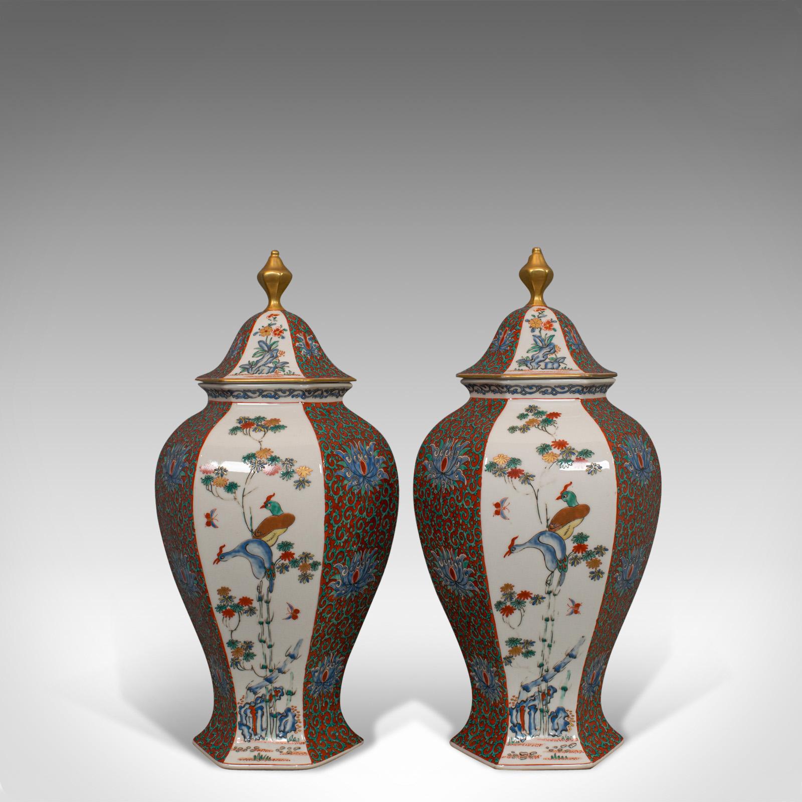 This is a pair of vintage hexagonal spice jars. Two Oriental, ceramic baluster urns with decorative avian and foliate scenes, dating to the mid-20th century, circa 1950.

Hexagonal form with profuse decoration
Displaying a desirable aged