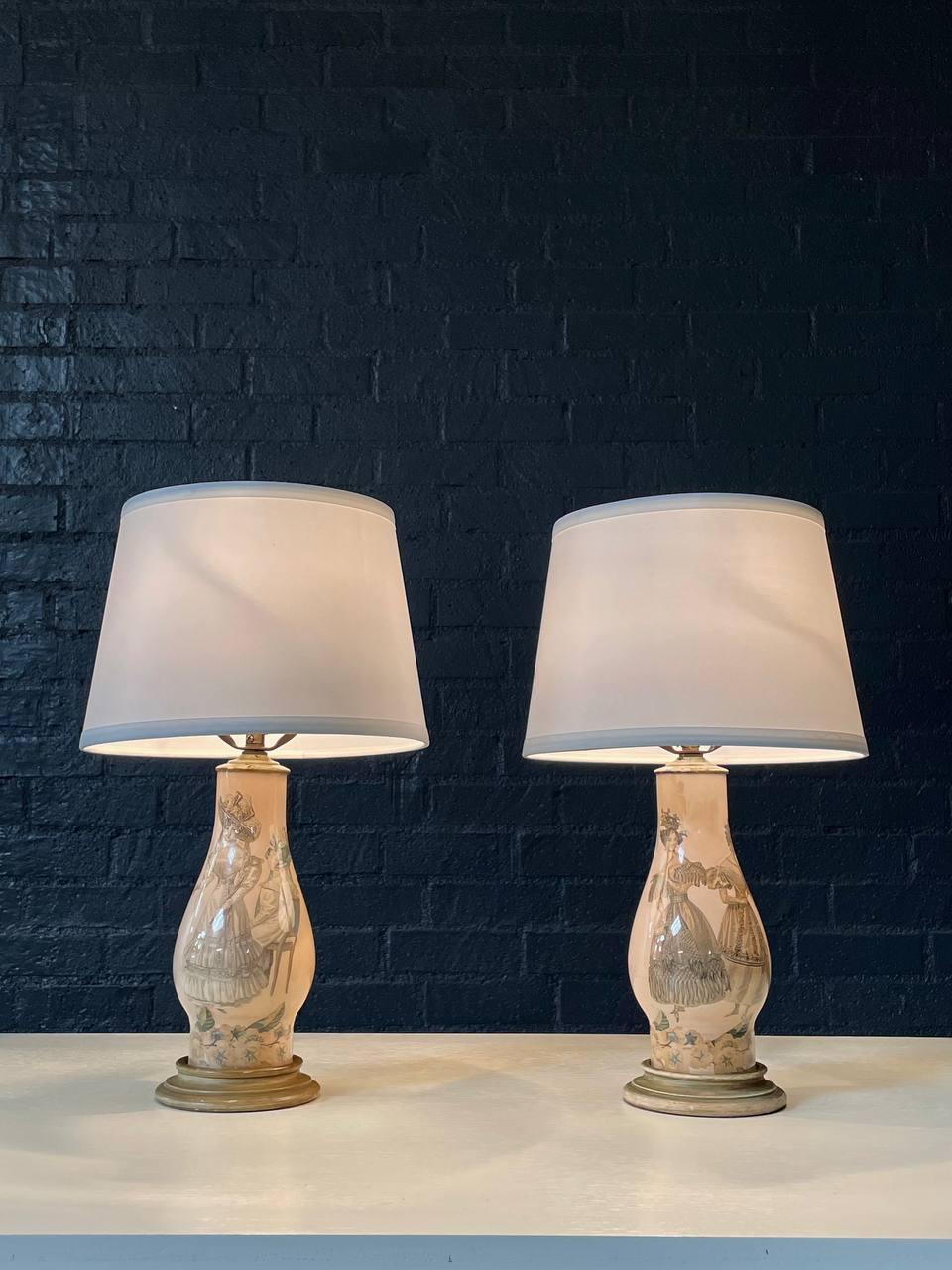 Condit: Cablata di recente, tende nuove

Materiali: Ceramica smaltata, basi in Wood invecchiato, paralumi nuovi

Questa affascinante coppia di lampade da tavolo in ceramica Hollywood Regency cattura l'eleganza e l'estrosità dell'arredamento di metà