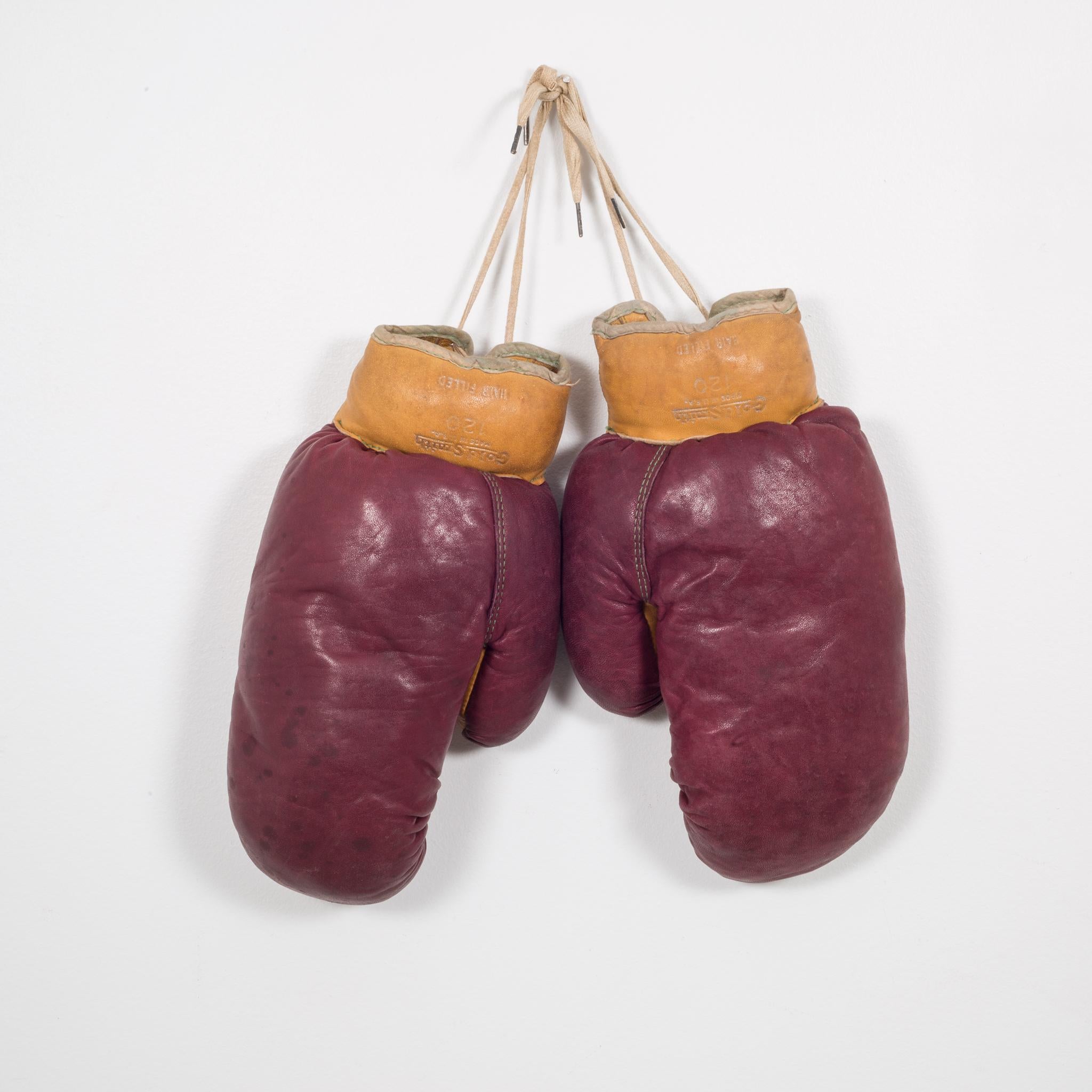 About

These are authentic vintage boxing gloves with reddish, brown leather and tobacco colored leather filled with horse hair. Each glove has green leather piping and tan laces. The leather is very soft and in good condition. Stamped 