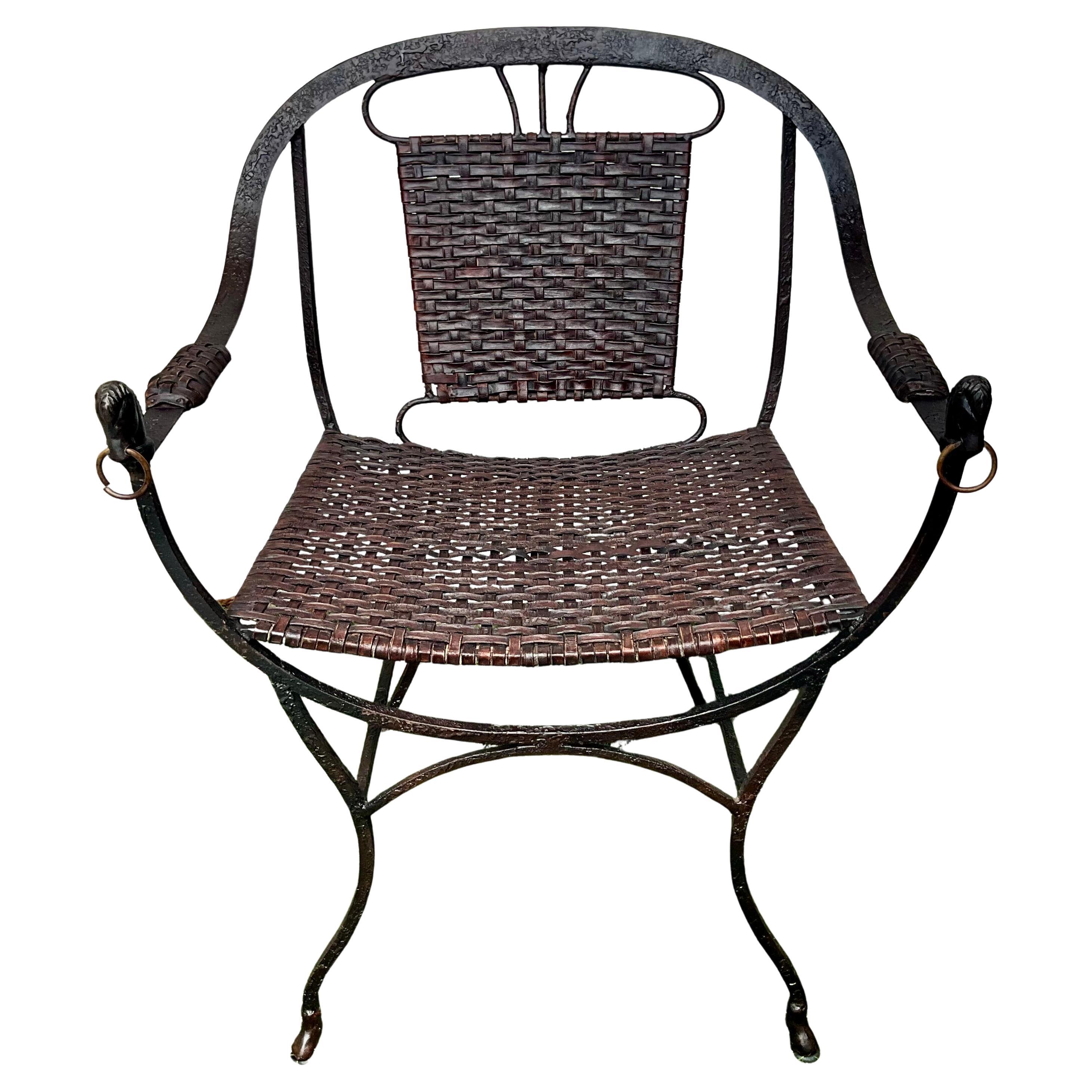 
Une paire distinctive de fauteuils vintage du milieu du 20e siècle.  avec des cadres en fer forgé et des embouts de tête de cheval sculptés sur les accoudoirs. Les sièges et les dossiers sont fabriqués à l'aide de sangles en cuir tressé, créant un