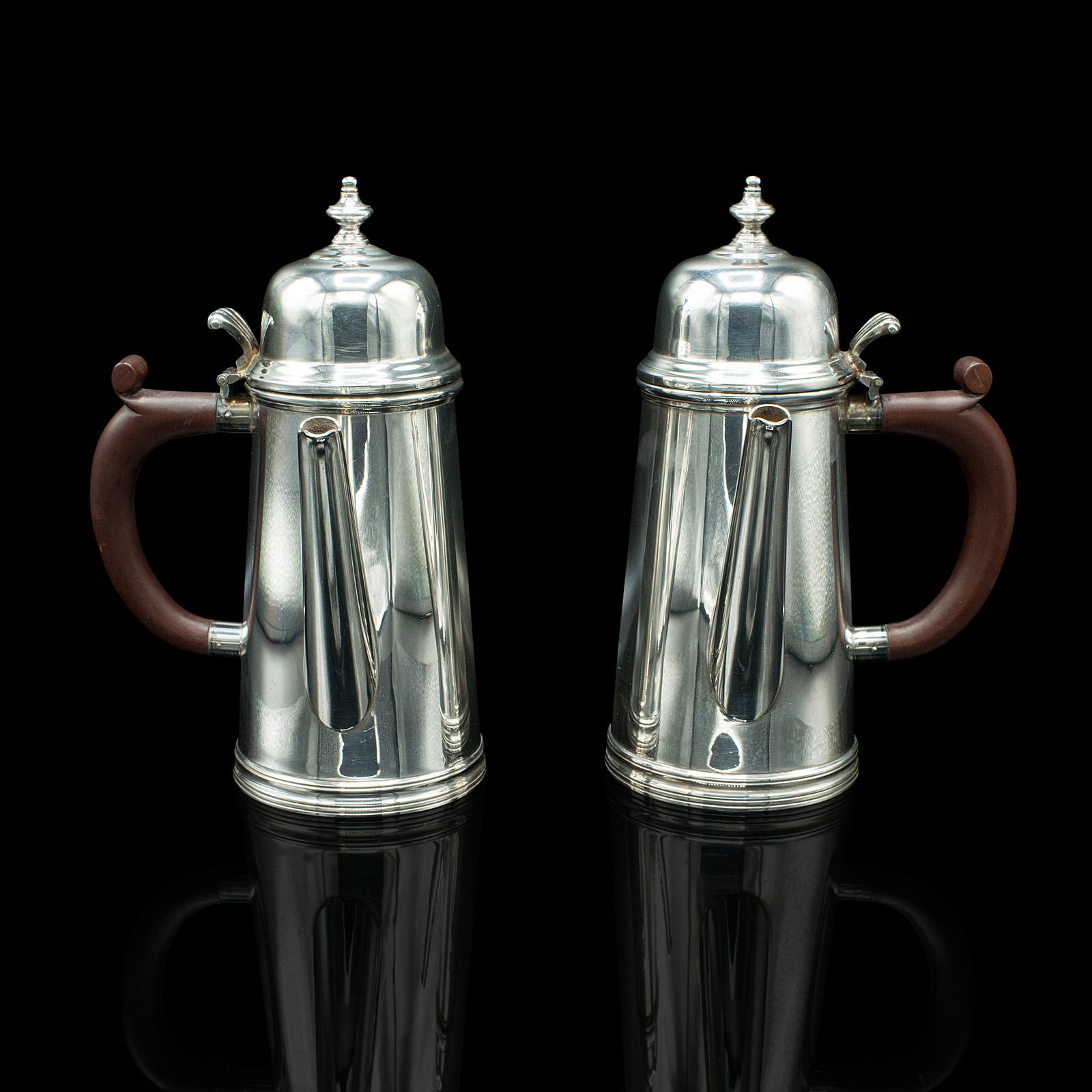 This is a pair of vintage hot chocolate jugs. An English, silver plated coffee serving pot, dating to the mid 20th century, circa 1940.

Fascinating serving jugs with a bright appearance and superb handles
Displays a desirable aged patina and in