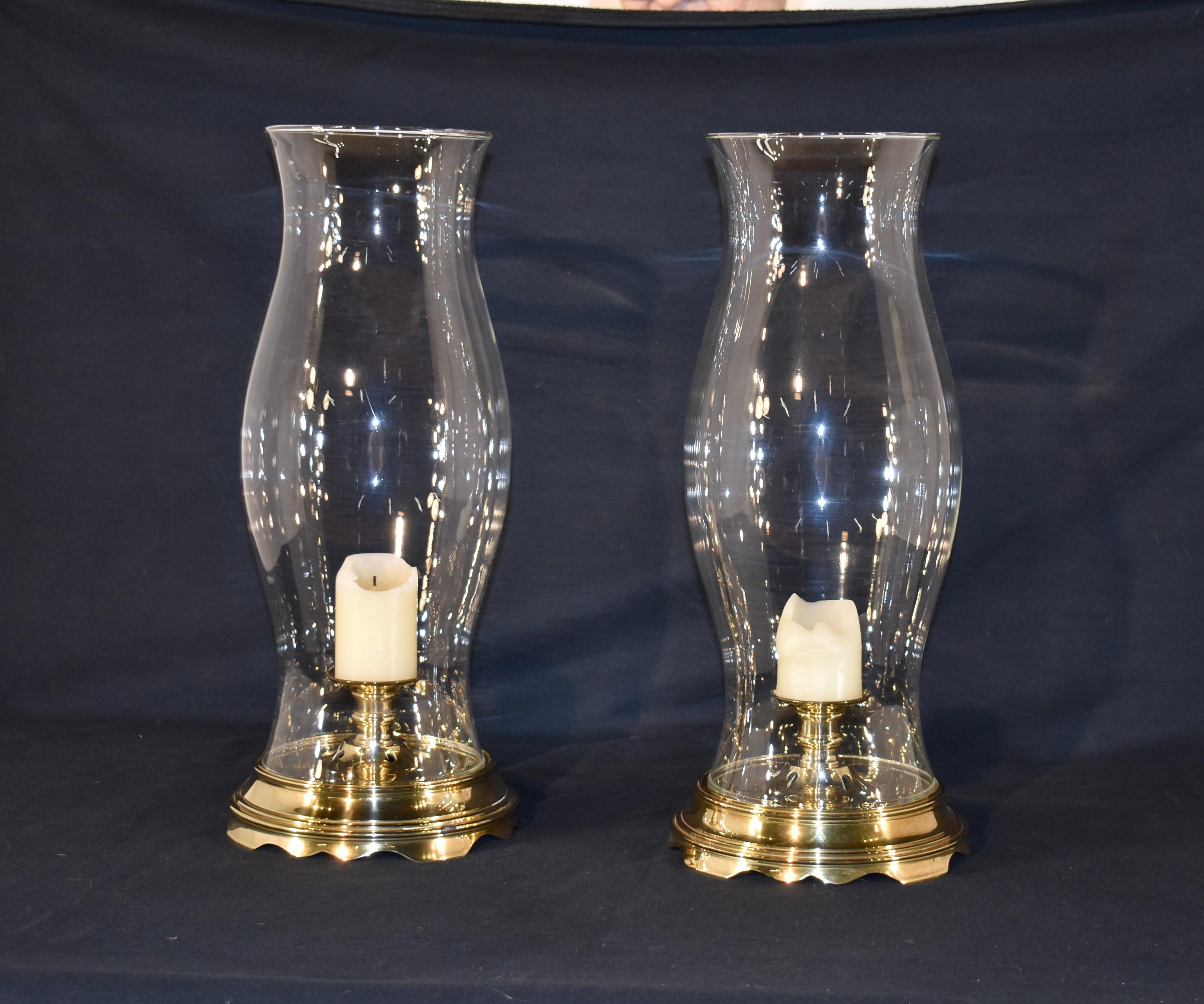 Pair of vintage hurricane lamps with a brass base and candle stand, surrounded by a glass hurricane shade.  These are unusual in that they do not fit a regular sized candle, they are for small pillars.  Lovely for any setting in a house or office.