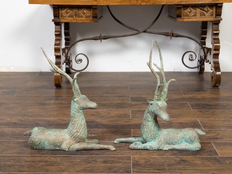 A pair of vintage Indian cast bronze deer garden sculptures from the mid 20th century, with detailed coats and verdigris patina. Created in India during the Midcentury period, this pair of garden sculptures attracts the attention with its charming
