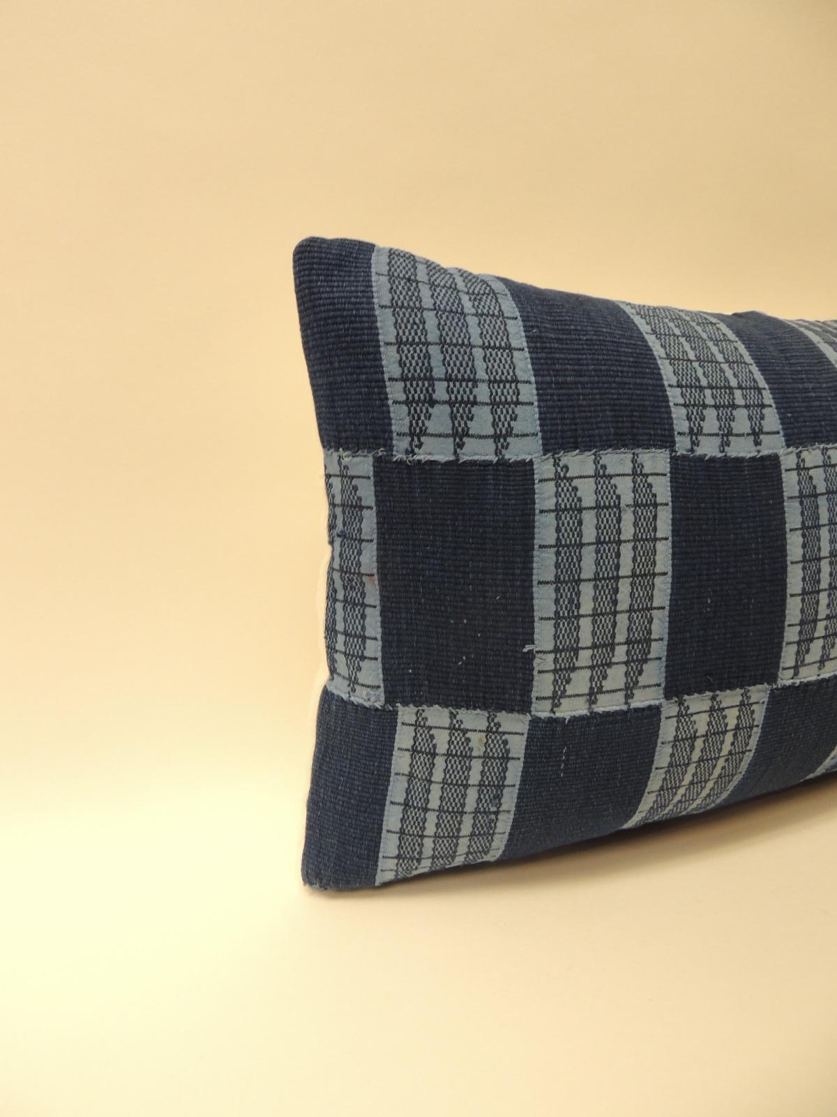 Vintage indigo and blue African woven and embroidered checkerboard pattern decorative lumbar pillow. Throw pillow handcrafted with a vintage textile from the artisanal fiber arts traditions of Africa. Decorative lumbar pillow finished with natural