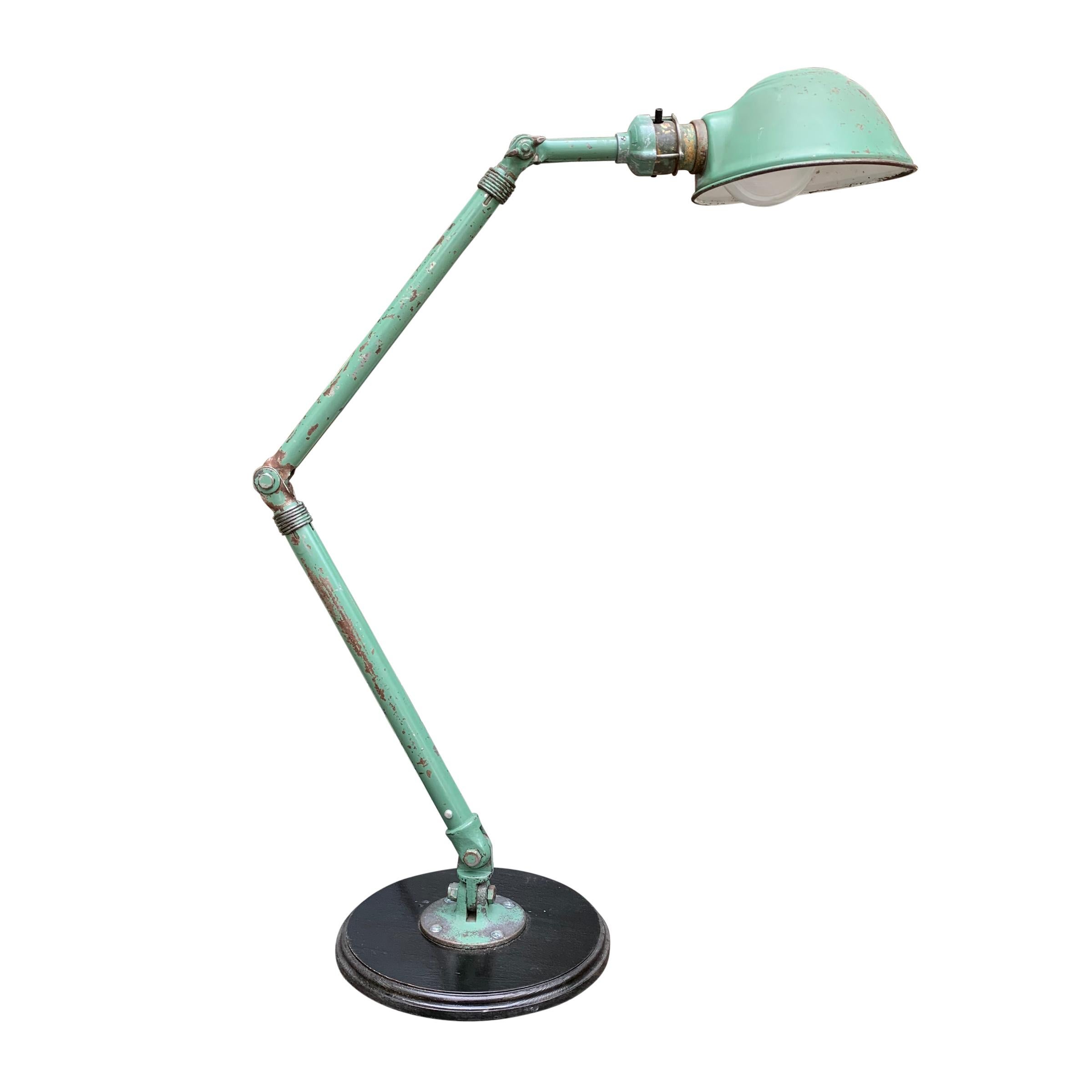 A pair of whimsical and expressive vintage American industrial steel articulated table lamps retaining their original green paint. Lamps like these were original used as task lamps in factories, but are perfect now as bedside lamps or on side tables