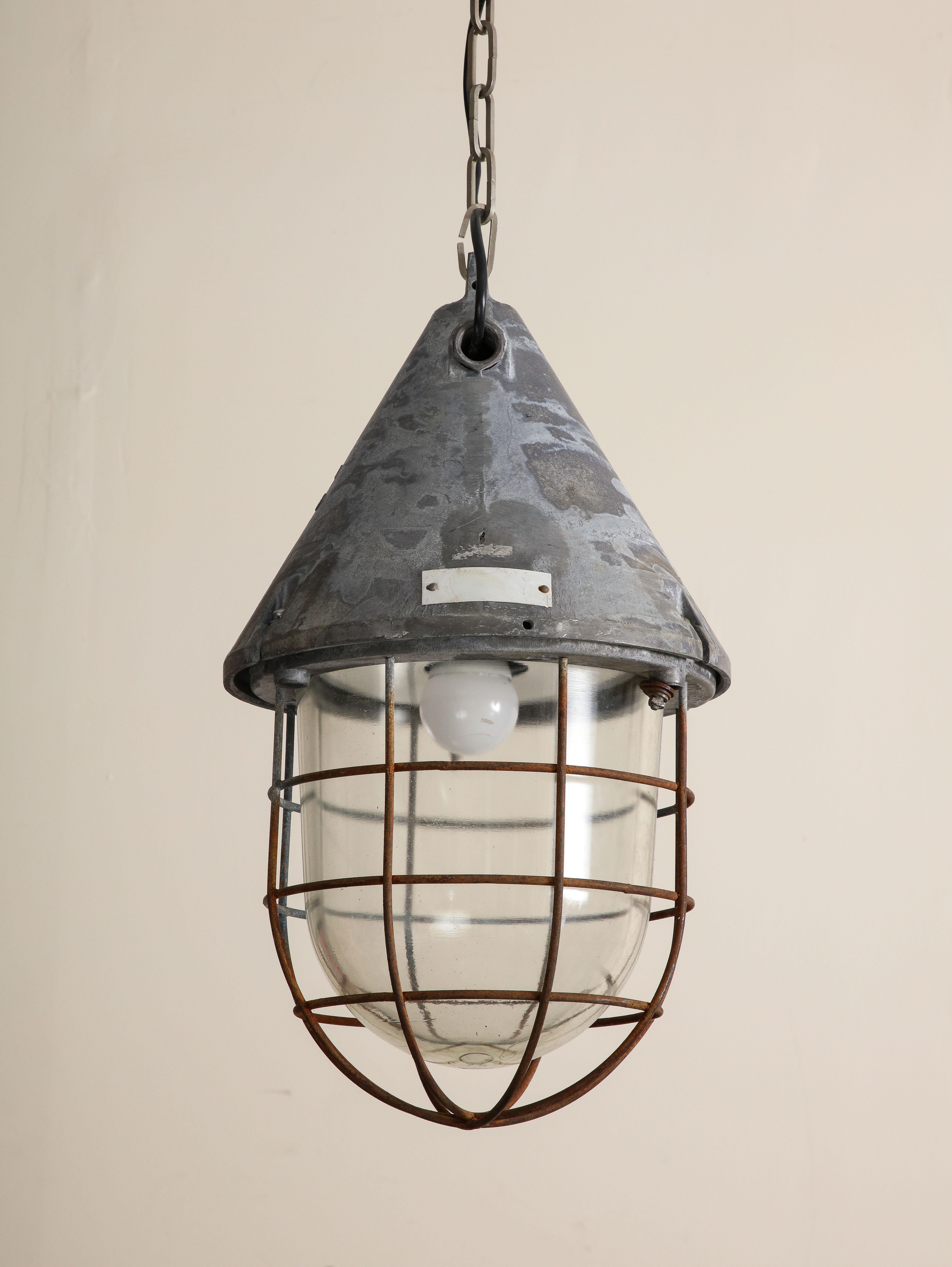 Pair of vintage industrial cast iron cage pendant lights, c. 1920. The cage is over clear glass cover. Conical cast iron tops have beautiful patina. Wired for USA, working condition.

12