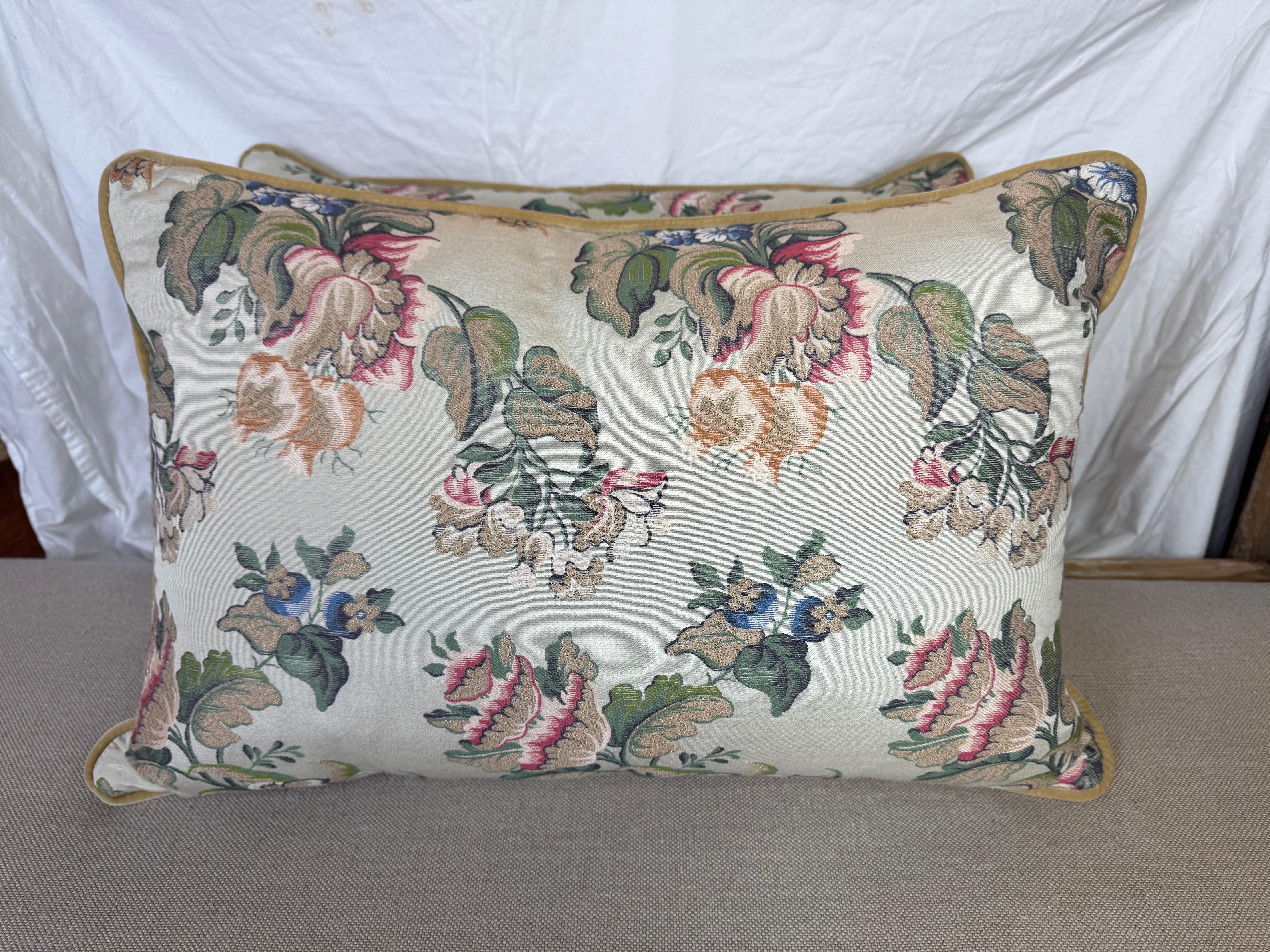 Ces oreillers présentent un design floral classique et élégant qui rappelle les textiles traditionnels européens ou de style vintage. Le tissu présente une délicate composition de grandes fleurs fluides dans des tons de rose tendre, d'or discret et