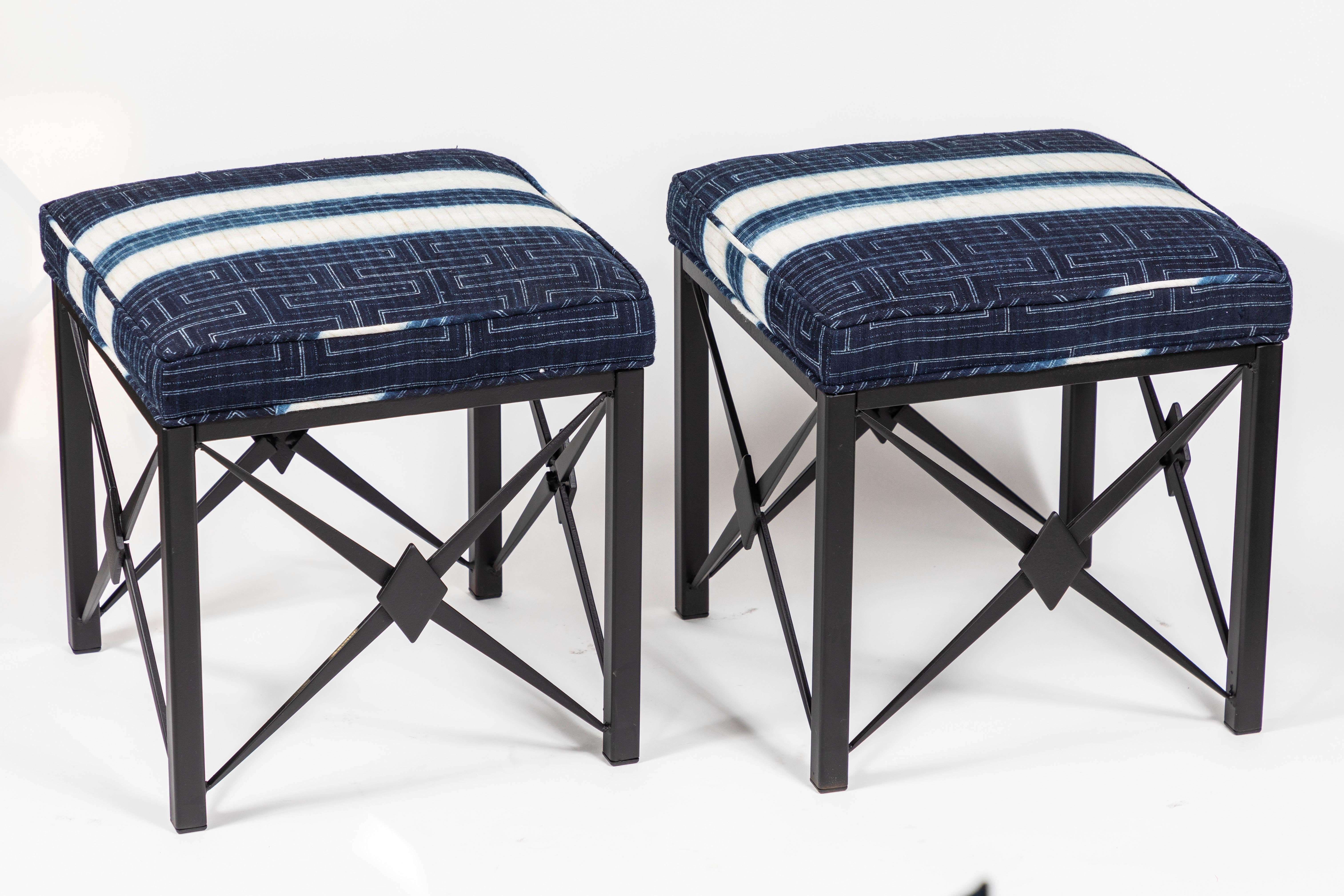 Pair of vintage iron footstools newly upholstered cushions in hand dyed blue and white cotton with new black powder-coated finish.