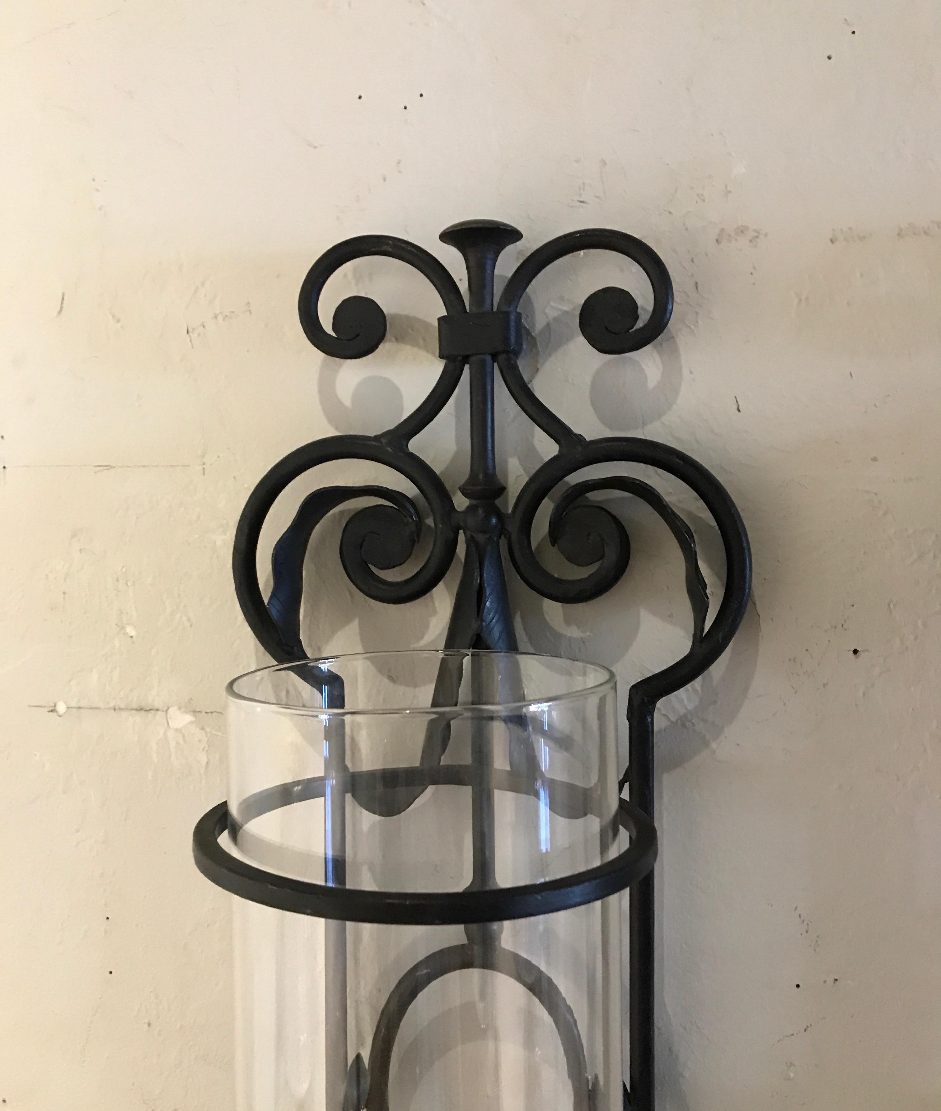 Vintage pair of black wrought iron wall mounted hurricanes with glass cylinders.
Hold pillar candles.