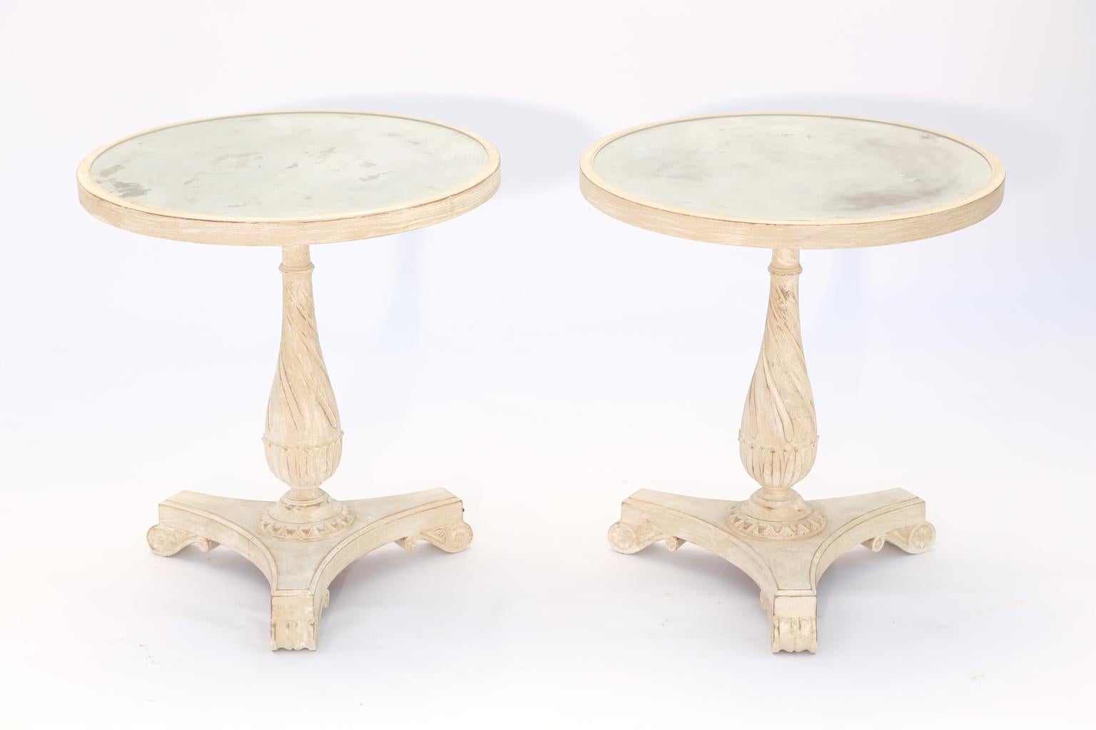Pair of side tables, having a pickled wood finish; each round top of distressed mirror plate, set upon a baluster-form, spiral-turned, pedestal base, on a concave, tripartite base, raised on scroll feet. 

Stock ID: D1694.
