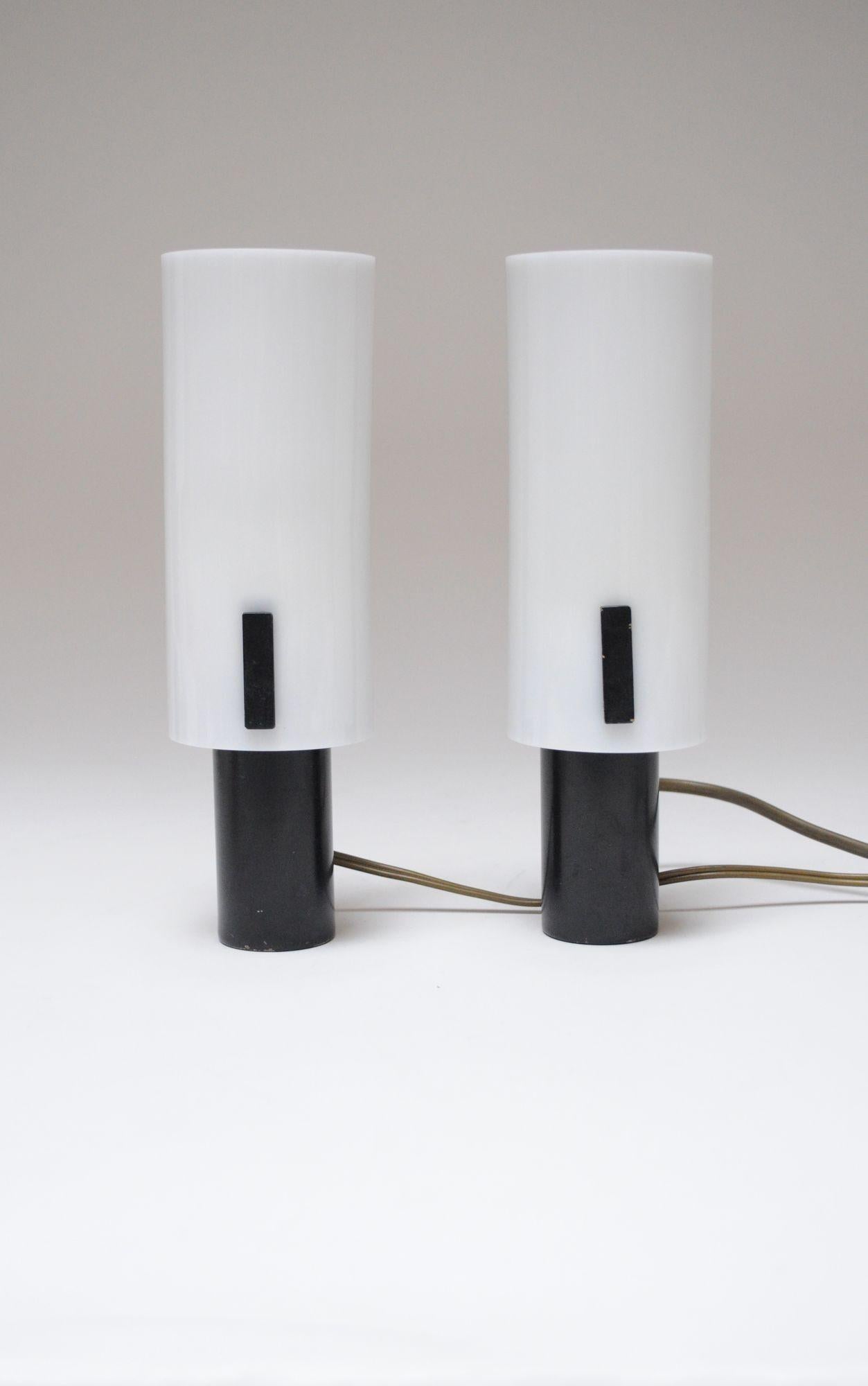 Petite wall sconces/table lamps in original condition by Stilux Milano (ca. 1950s, Italy).
Composed of black metal cylinders with brass hardware and black metal brackets supporting white acrylic shades.
Elegant lamps suitable for wall mounting or