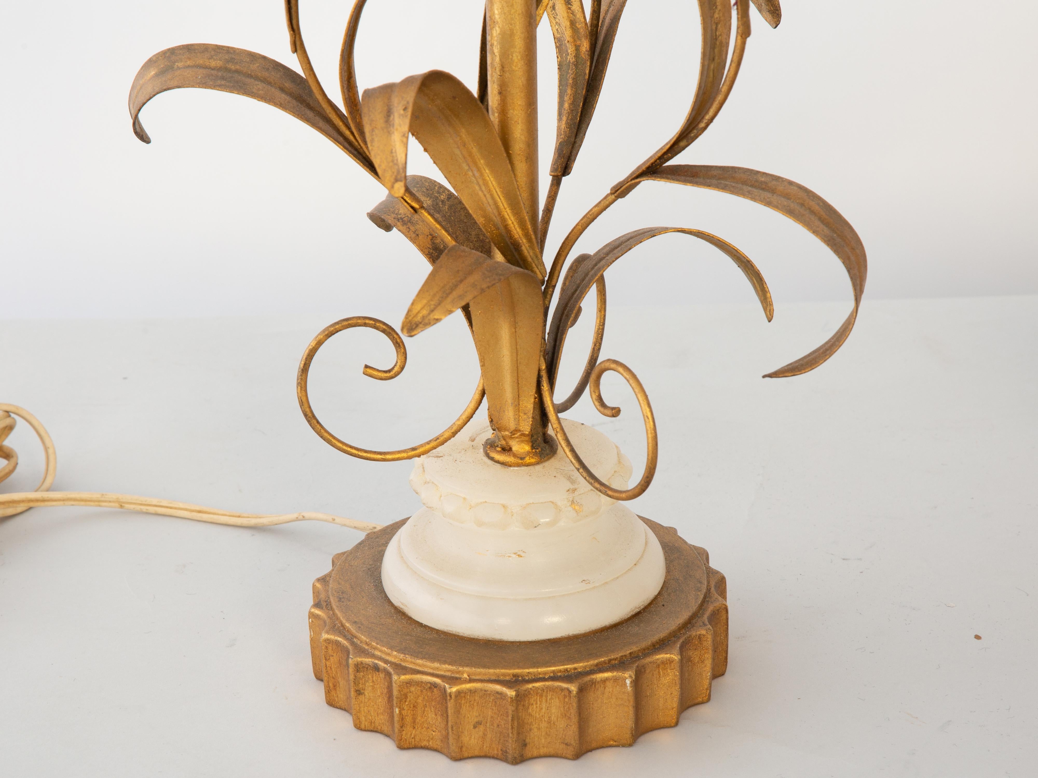 Paire de lampes de table vintage à motifs floraux. Chacune représente un bouquet de trois tulipes en albâtre avec des tiges, des feuilles et des volutes en métal doré, sur une base ronde cannelée en bois doré. 

Stock ID : D2986
 
