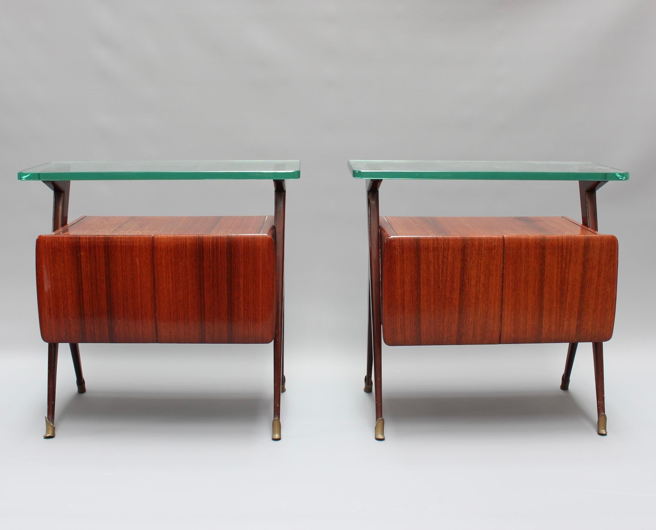 Pair of Mid-Century Italian bedside tables / night stands attributed to Silvio Cavatorta (circa 1950s). Very stylish pieces of teak veneered wood with abundant character. There are two horizontal surfaces for storage or display with the top made of