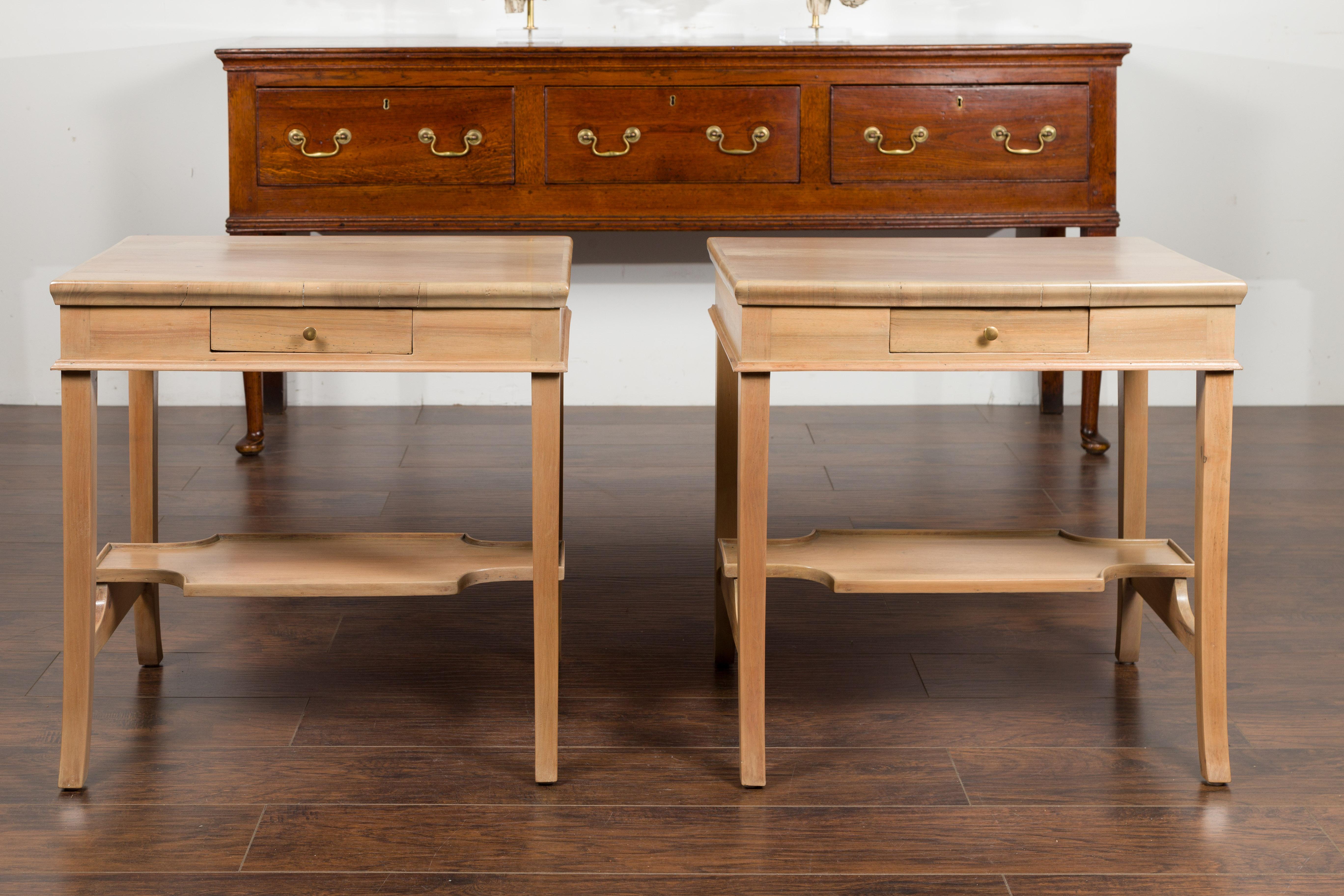 A pair of vintage Italian bleached walnut side tables from the mid-20th century, with single drawers and tray shelves. Created in Italy during the mid-century period, each of this pair of side tables features a rectangular top sitting above a single