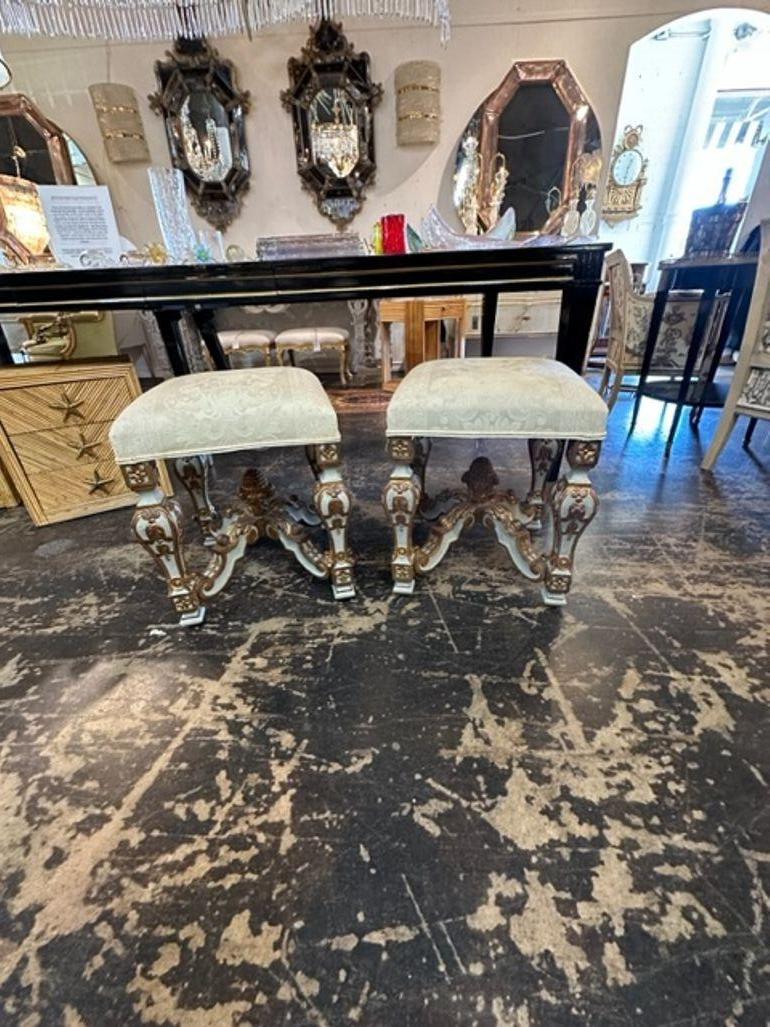 Elegant pair of Italian vintage carved and parcel gilt benches. Featuring beautiful intricated details on the bases and upholstered in a gorgeous creme colored fabric. Very special!!