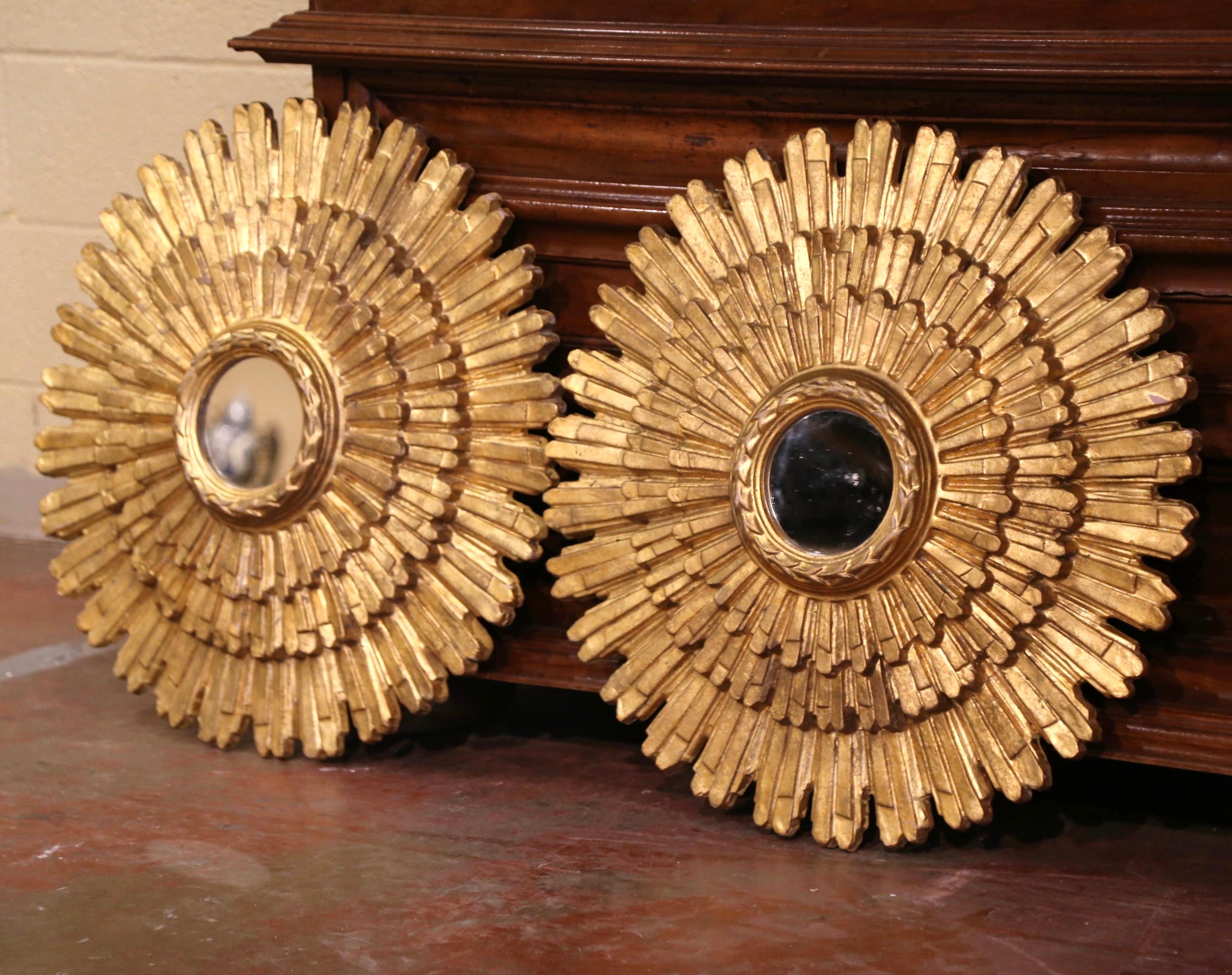 Add a beautiful shine to your home with this pair of eye-catching sun mirrors. Created in Italy circa 2010, each mirror has a Classic Sunbeam shape with three-tier rays, a central circular mirror plate encircled by a band carved and gilt to resemble
