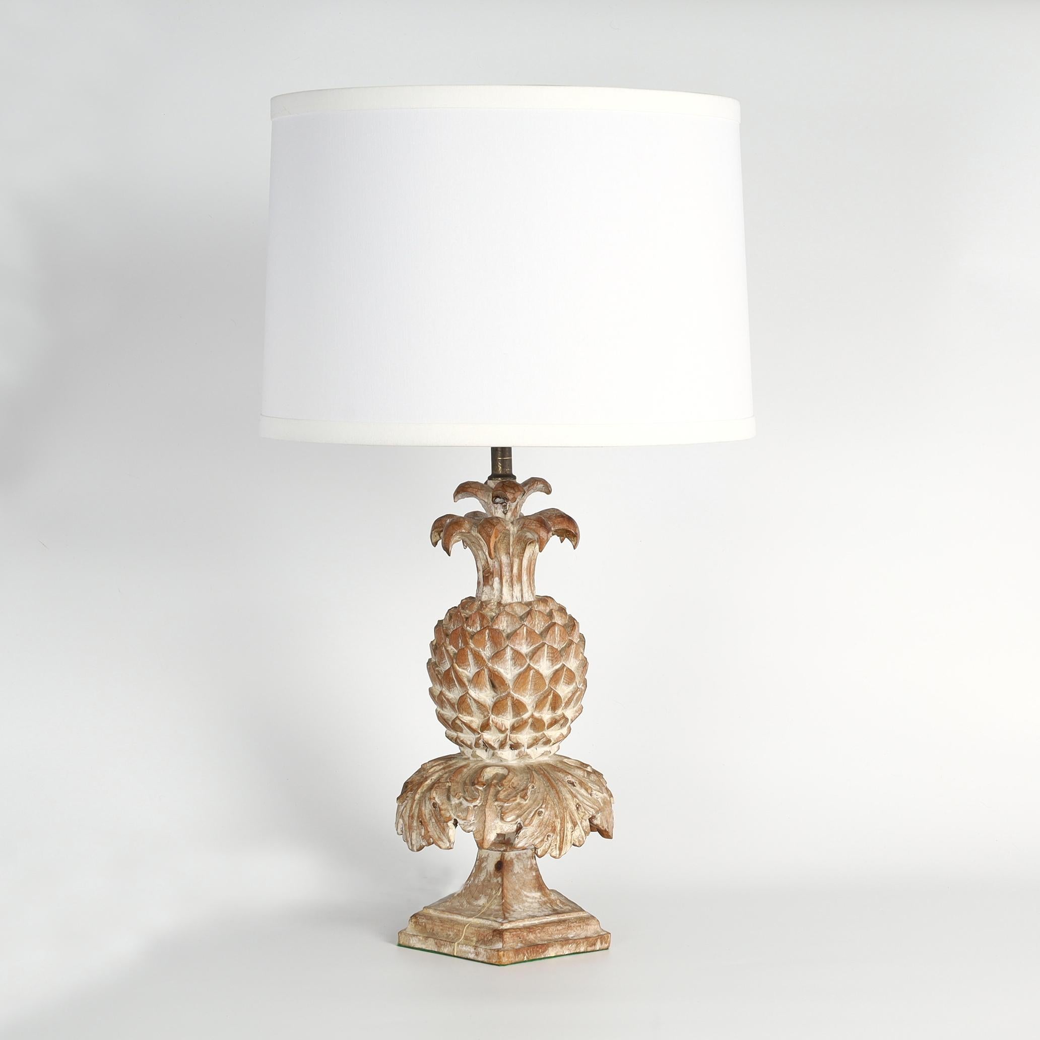 Mid century neoclassical style pair of table lamps having stylized hand carved pineapples on square plinths with a chic white washed finish.