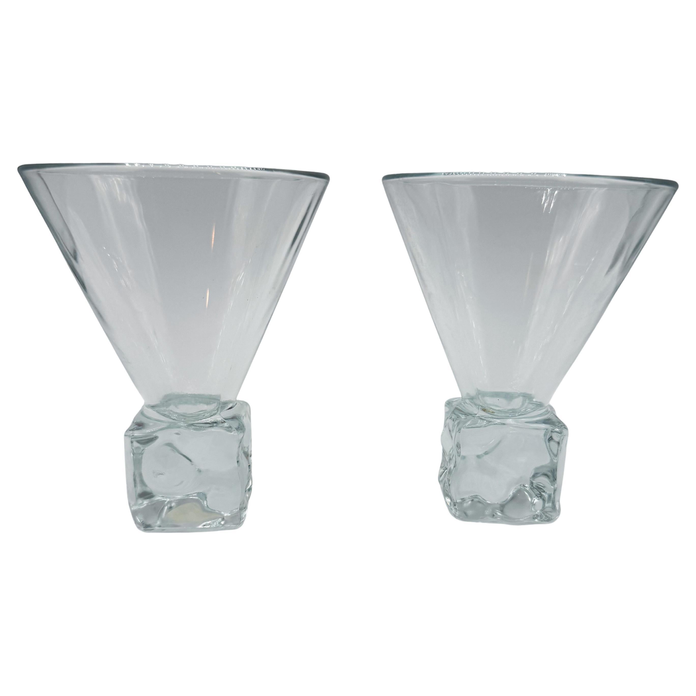 Elegant and eye-catching, this pair of vintage Italian martini glasses features a distinctive solid glass base designed to resemble melting ice cubes—adding a sculptural, tactile foundation to their sleek conical bowls. Marked Fabrique in Italy on