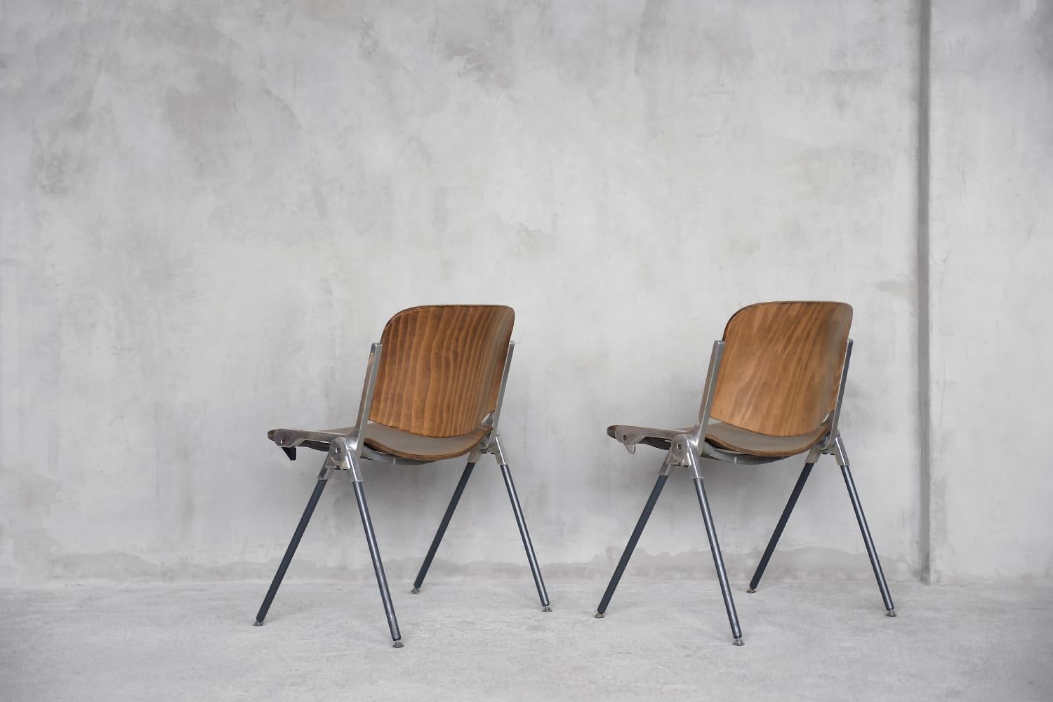 This set of Agorà chairs was designed by Paolo Favaretto for the Italian manufacturer Emmegi during the 1970s. The frame is made of anodized aluminum. The seat and backrest are made of bent beech plywood. Furniture made of this material combines the