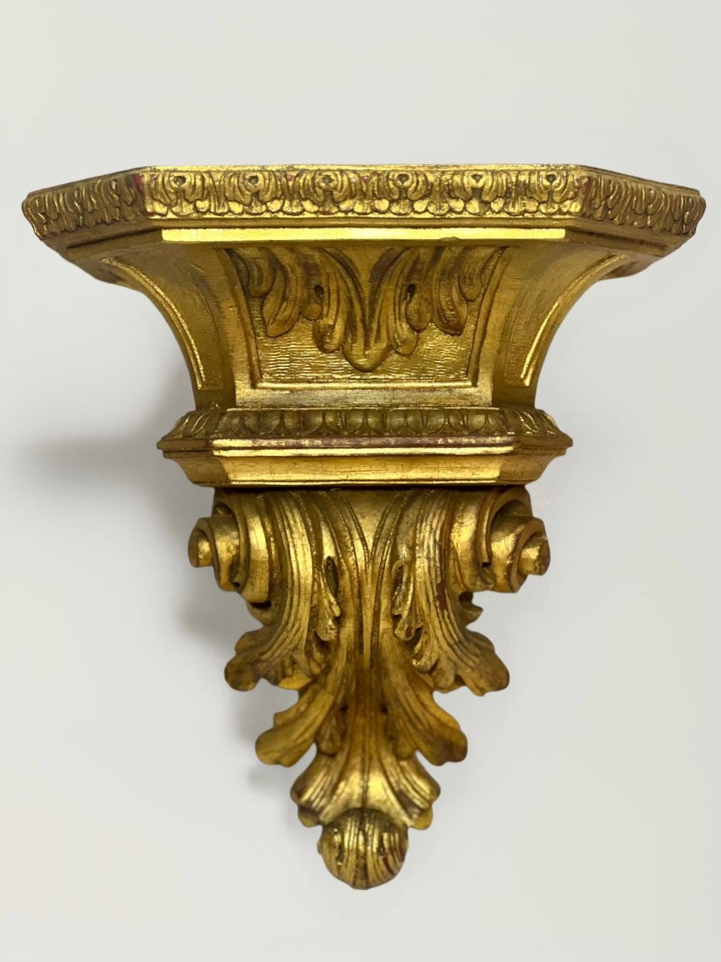 Striking pair of vintage midcentury Italian Florentine style wall bracket shelves crafted of giltwood. Beautifully shaped with a robust architectural form and decorated with carved acanthus leaves and scrolls. Large curio shelf is perfect to display