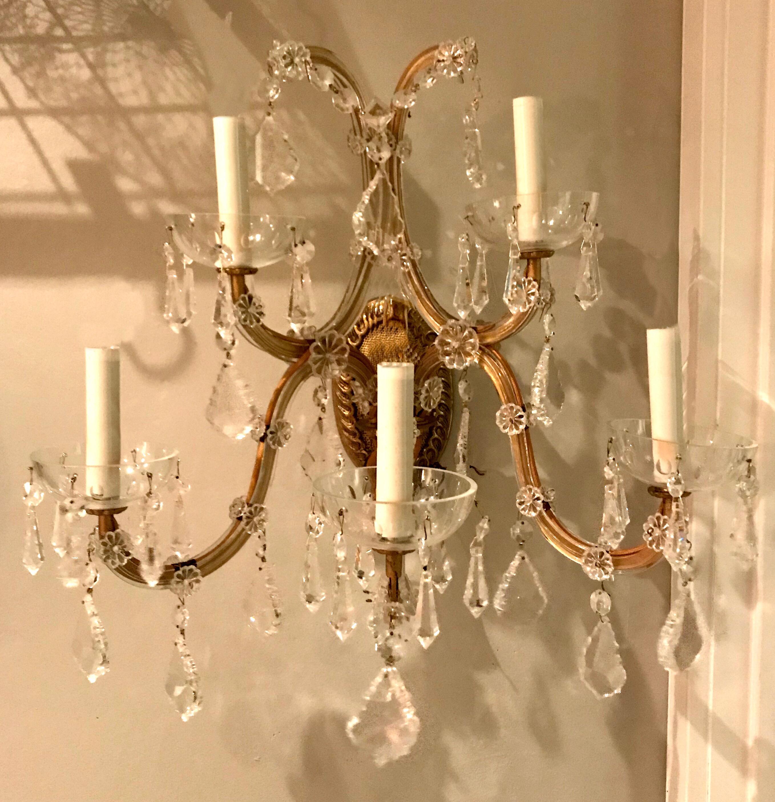 A pair of five-light vintage Italian gilt metal sconces with crystals. Each light with glass bobeche with drop crystals.