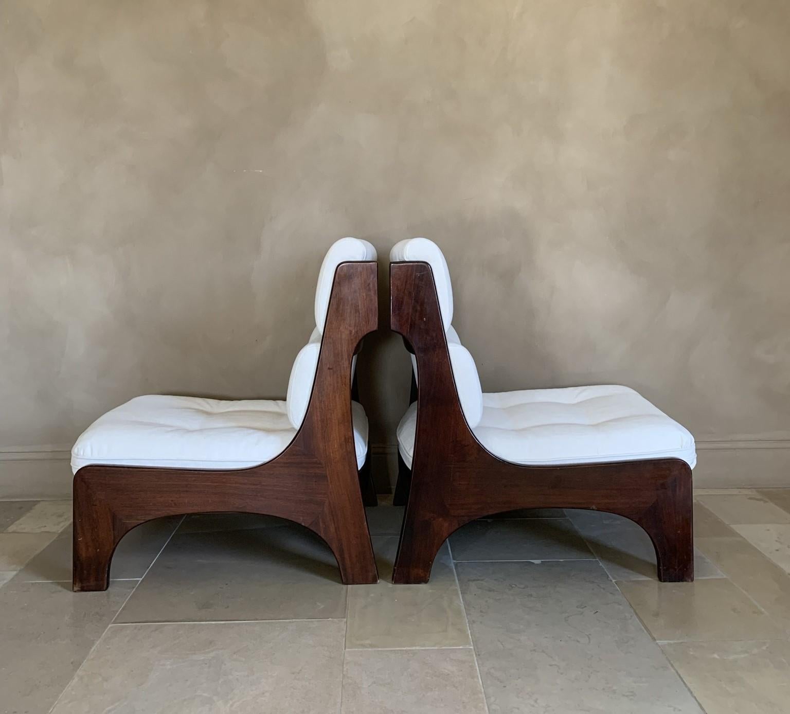 A high quality pair of Italian lounge chairs, circa 1965. Hand assembled in solid rosewood these chairs resonate stylish Italian craftmanship and design. They are concieved in a subtle cubist style with lots of eye for detail. The woodconnections