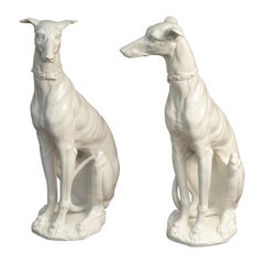 Paire de chiens lévriers en porcelaine italienne du milieu du siècle dernier assis sur un socle