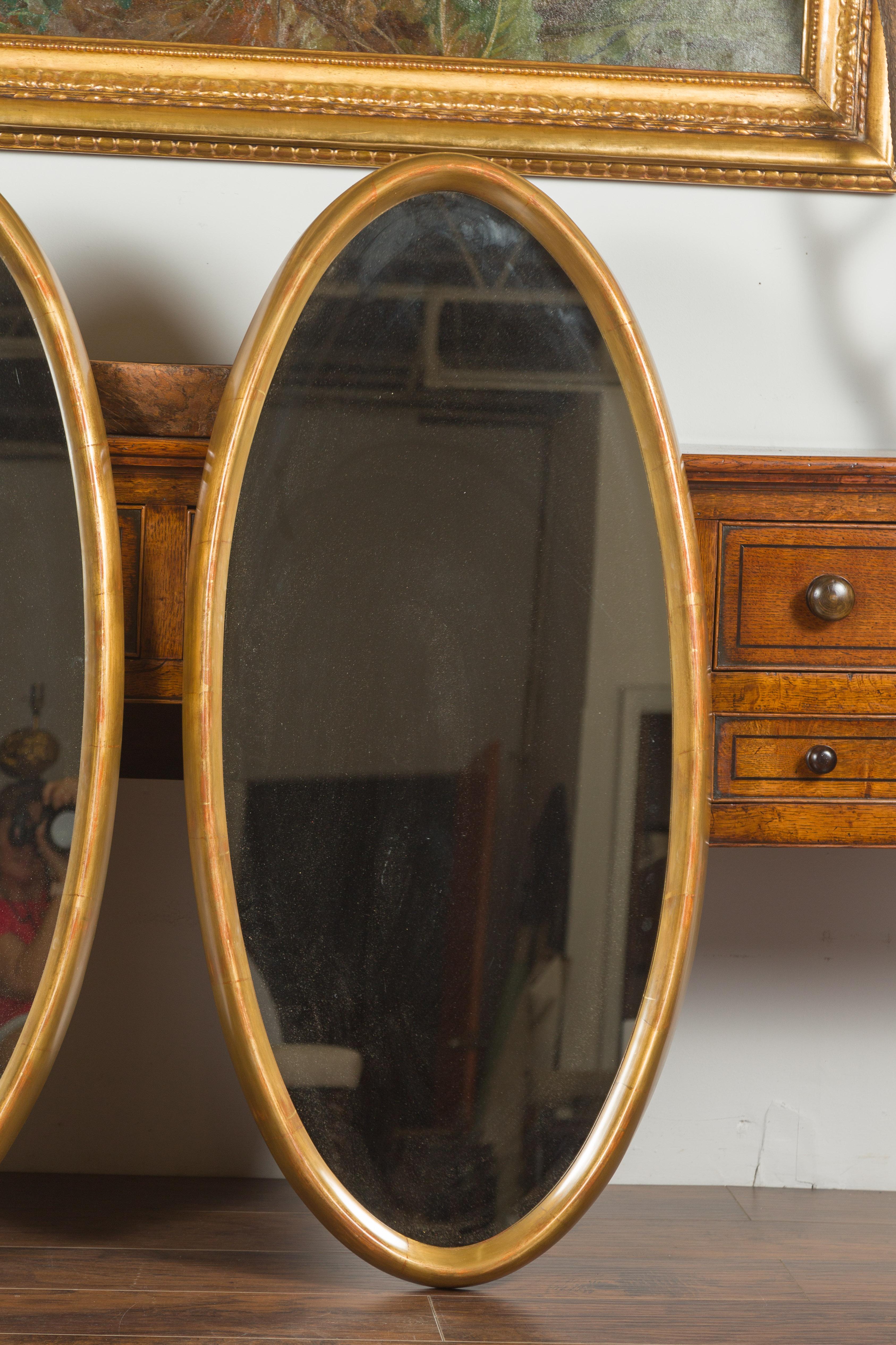Miroir Paire de grands miroirs ovales italiens du milieu du siècle dernier en bois doré aux lignes épurées en vente