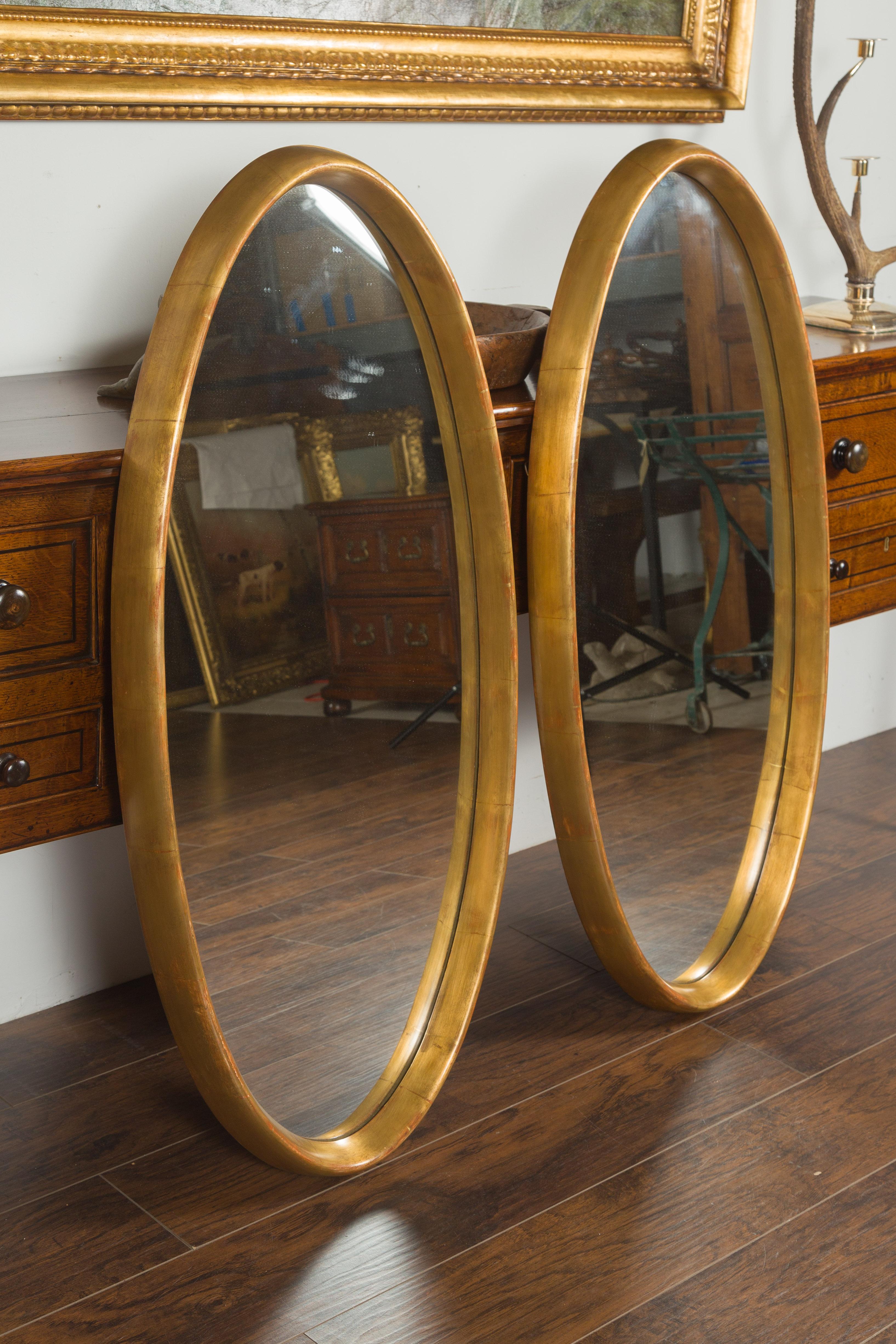 Paire de grands miroirs ovales italiens du milieu du siècle dernier en bois doré aux lignes épurées en vente 1