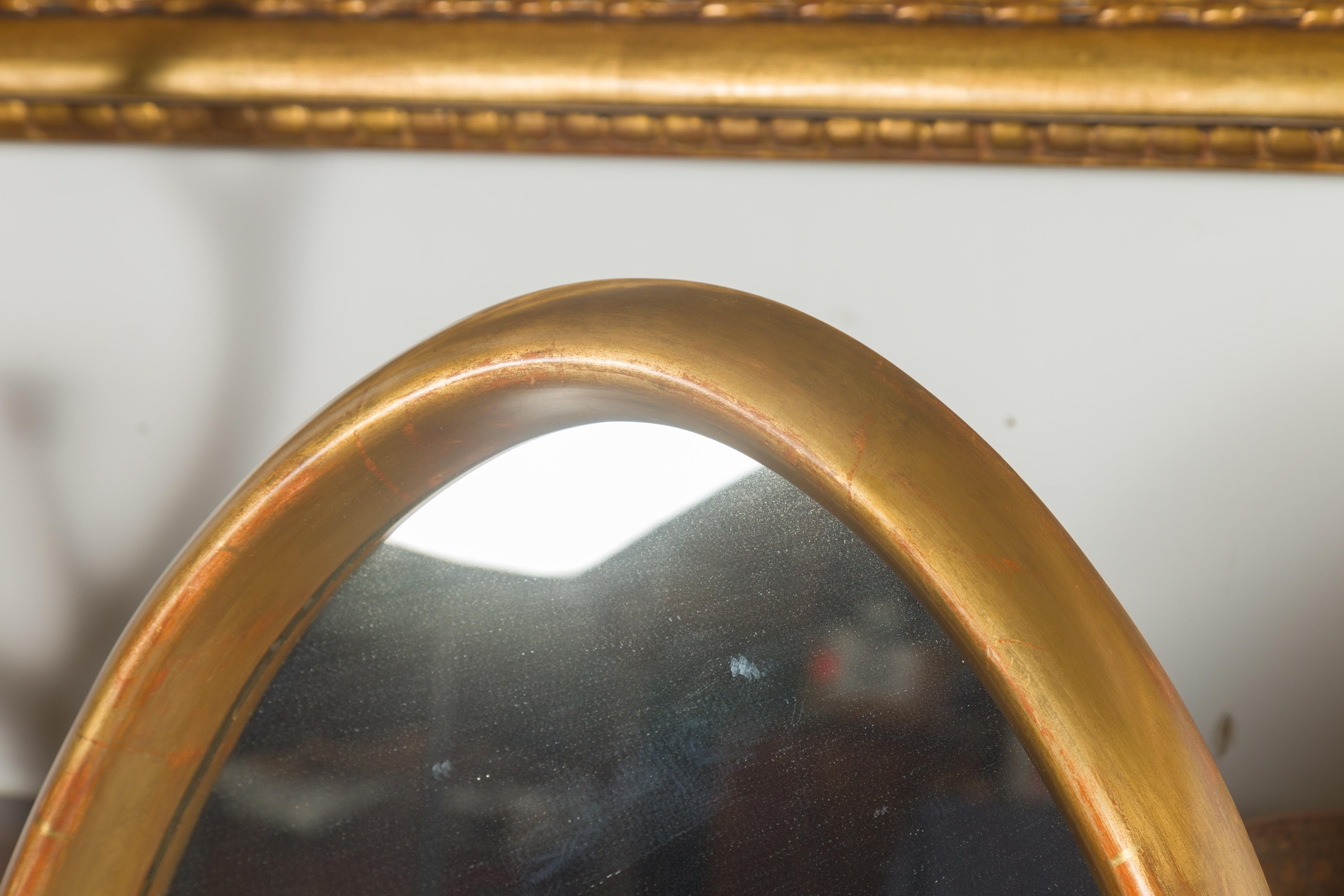 Paire de grands miroirs ovales italiens du milieu du siècle dernier en bois doré aux lignes épurées en vente 3