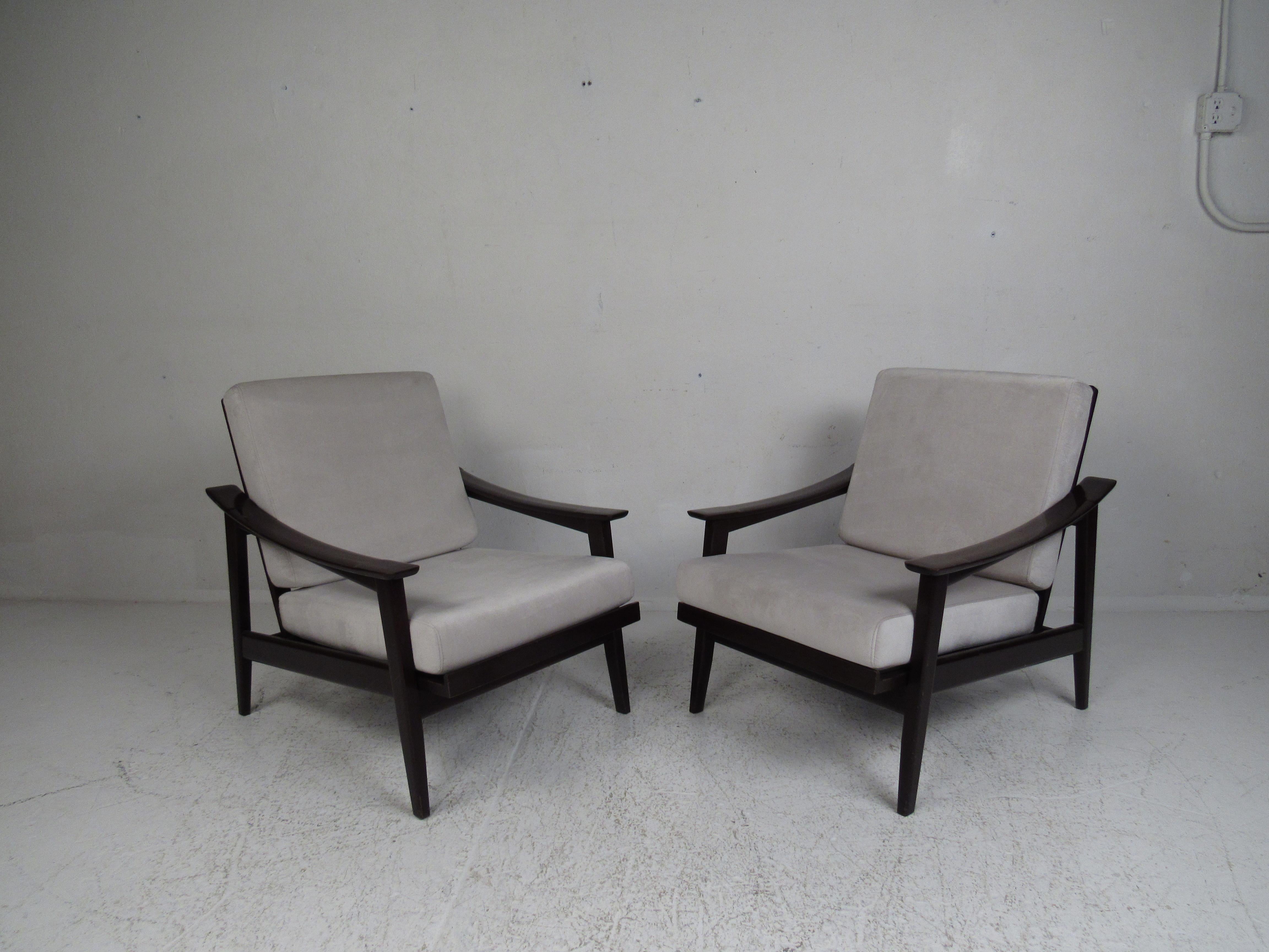 This stunning Mid-Century Modern armchair has the ability to recline, offering extreme comfort in any seating arrangement. The plush off-white velour upholstery covers two overstuffed removable cushions. This sleek pair boasts sloping armrests with