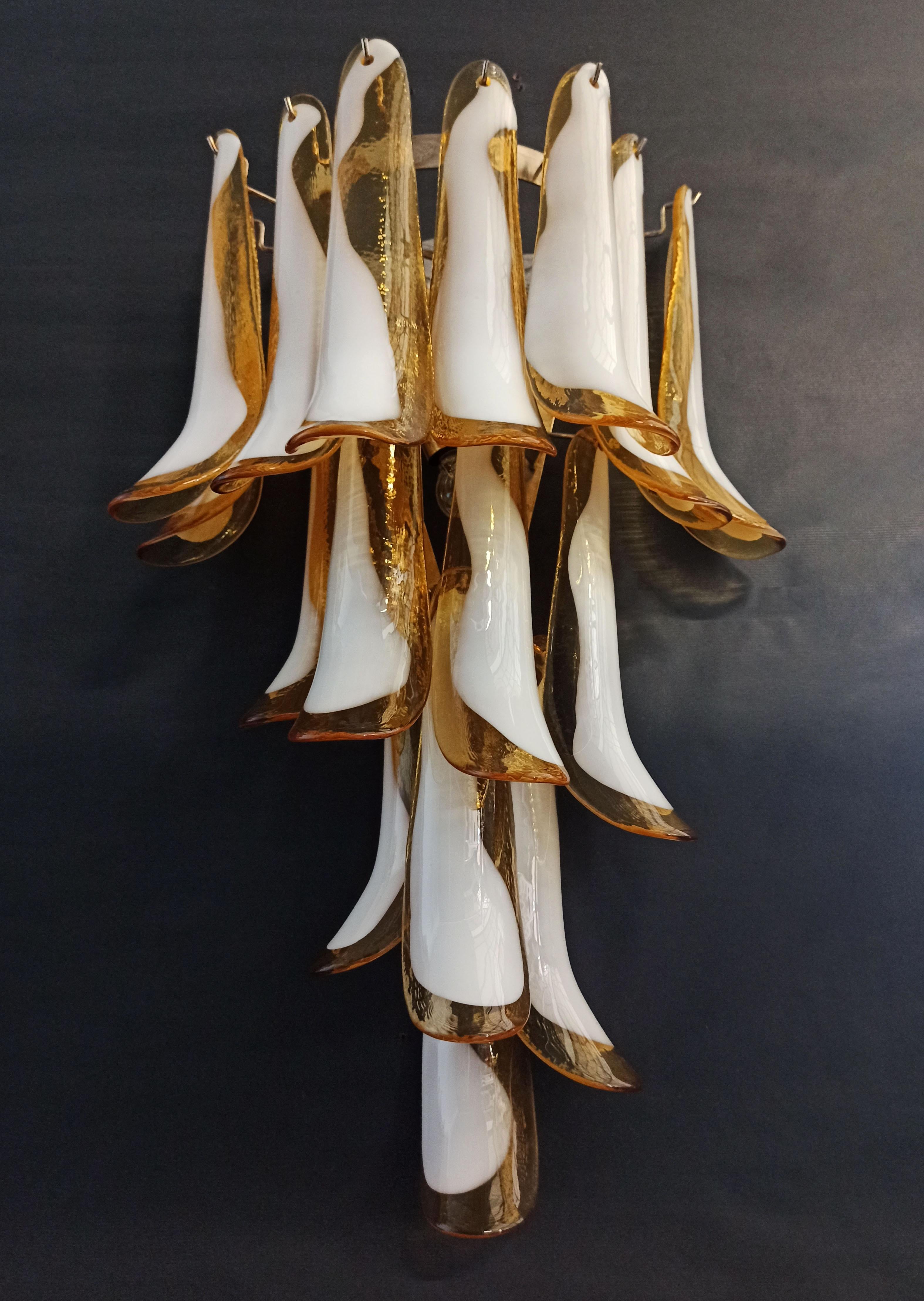 Pair of vintage Italian Murano wall sconces. Wall lights have 16 caramel and white “lattimo” glasses (for each applique) in a nickel-plated metal frame. Decorative object of great importance.
Period: late XX century
Dimensions: 27.90 inches (72