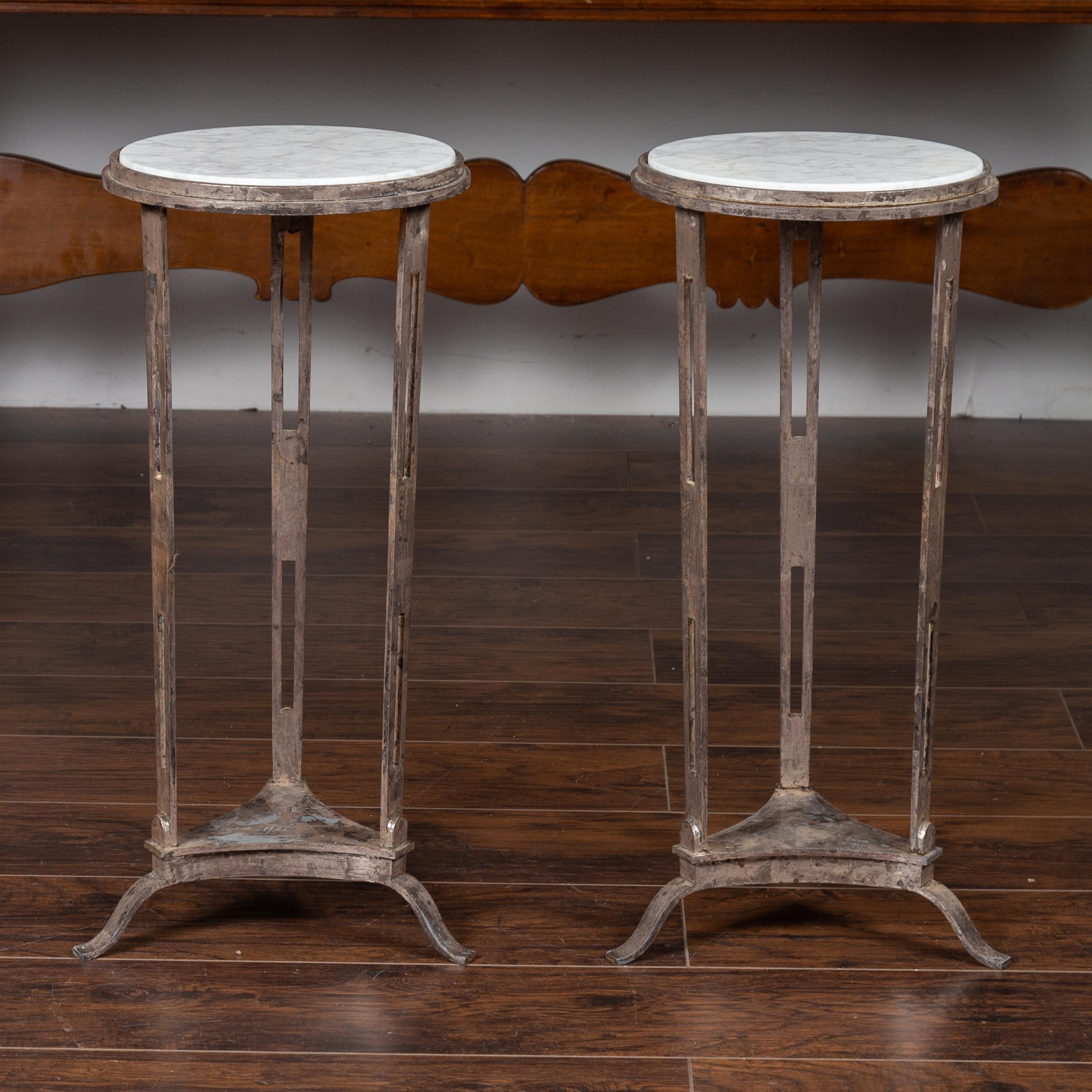 A pair of Italian vintage silver leaf drinks tables from the mid-20th century, with white veined marble tops. Born in Italy during the midcentury period, each of this pair of drinks tables features a circular white marble top resting on a silver