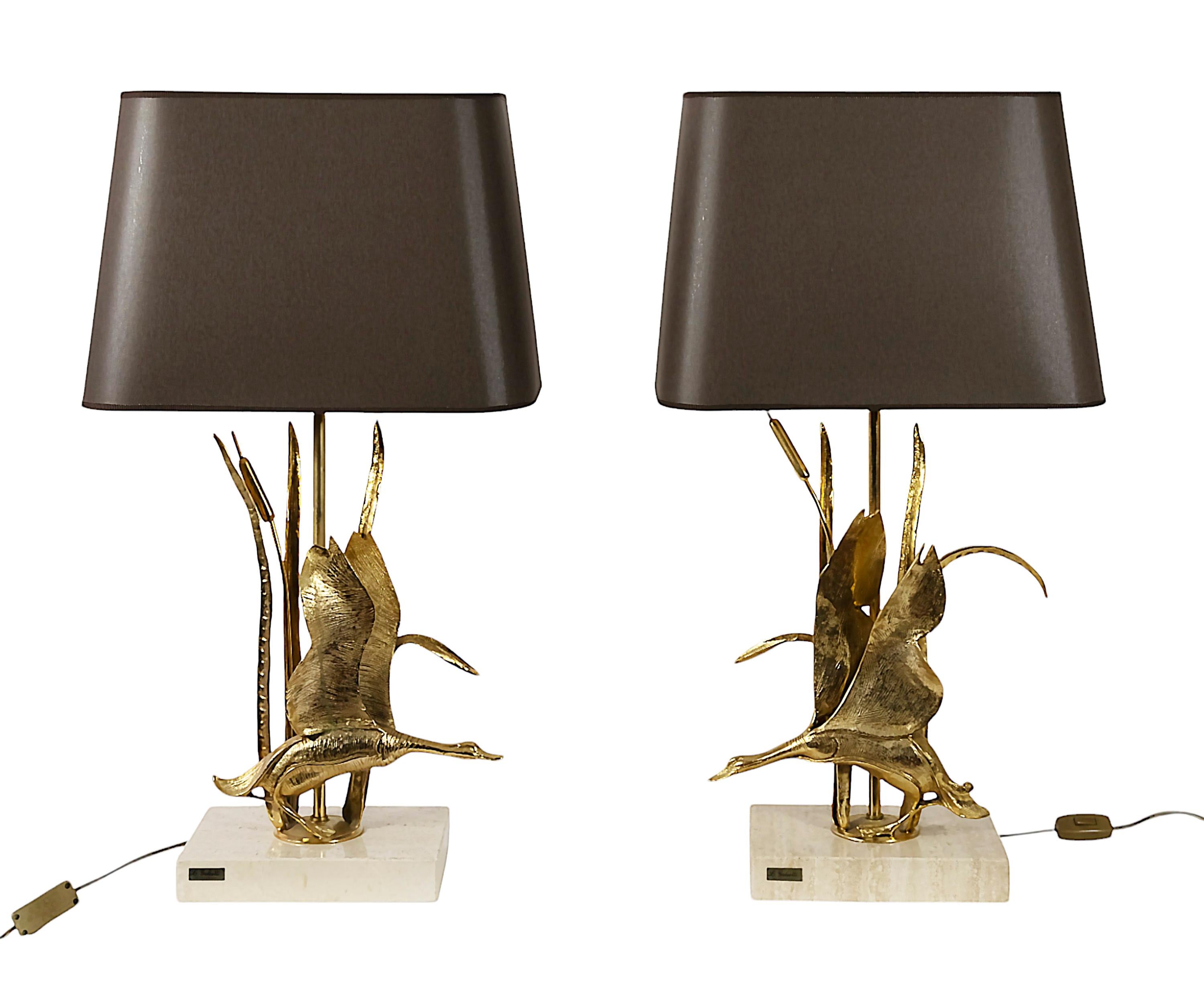 Vintage pair of Italian table lamps by Lanciotto Galeotti  with flying birds in gilt bronze and square travertine marble base. 
Lamps are with the new made brown color textile shade with gold inside.
Bulb holders: E27.
Labeled on the marble.
Very