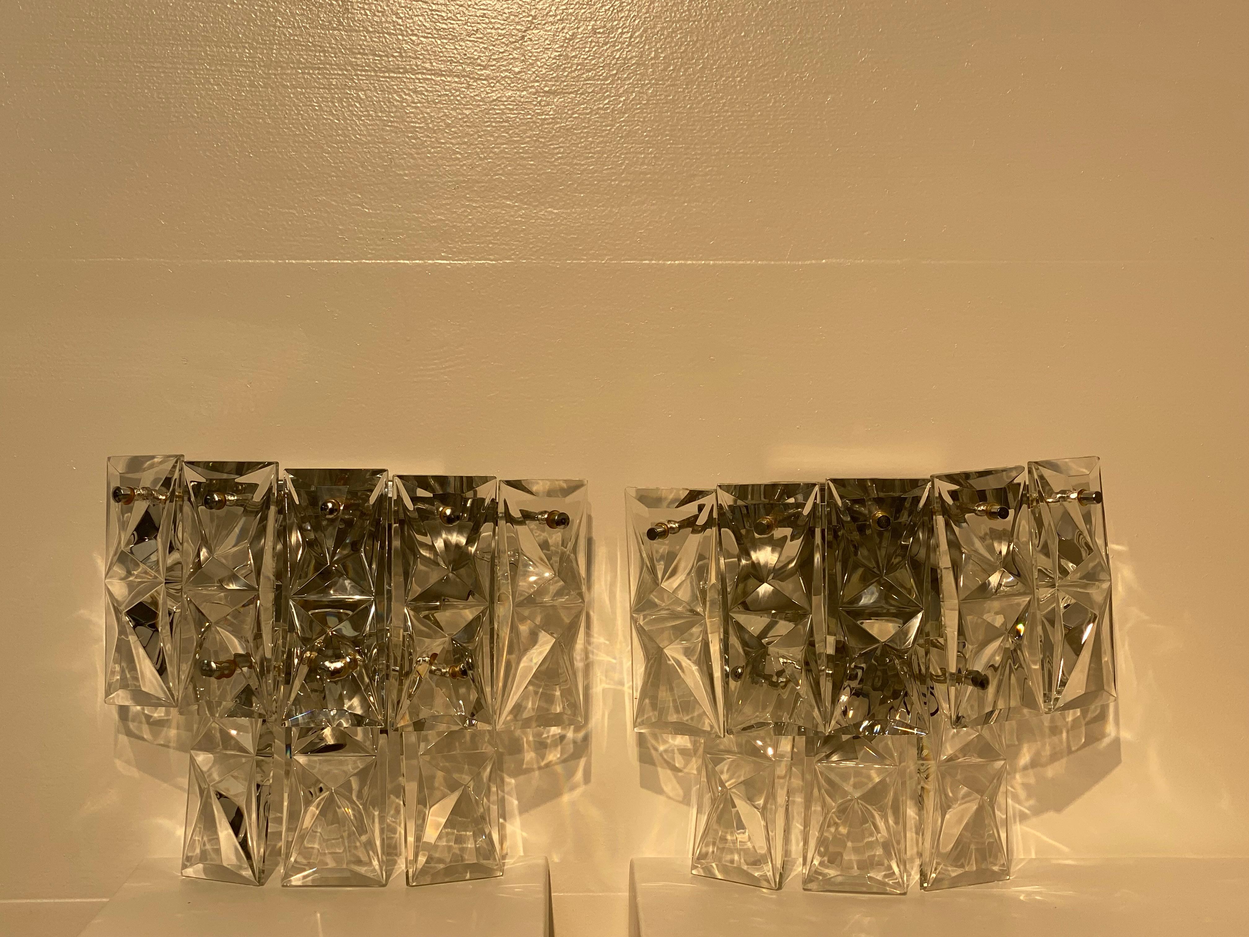 Elegant pair of Italian Wall Lamps,
from the 1960 ies,
made out of rectangular Crystal plates mounted on a Chrome base,
inside the lamps are 3 light points,
very decorative and refined pair of lamps,
the radiance of the Crystal gives a magic