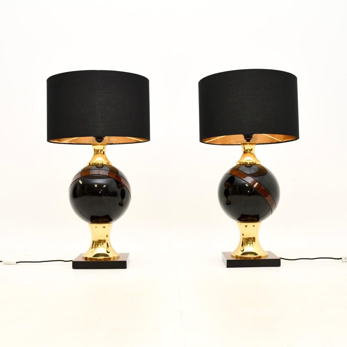 Une très grande et élégante paire de lampes de table italiennes vintage en noyer et laiton, datant des années 1970.

Ils sont très substantiels et impressionnants, la qualité est superbe. Ils présentent de grands orbes au centre du bois laqué noir,