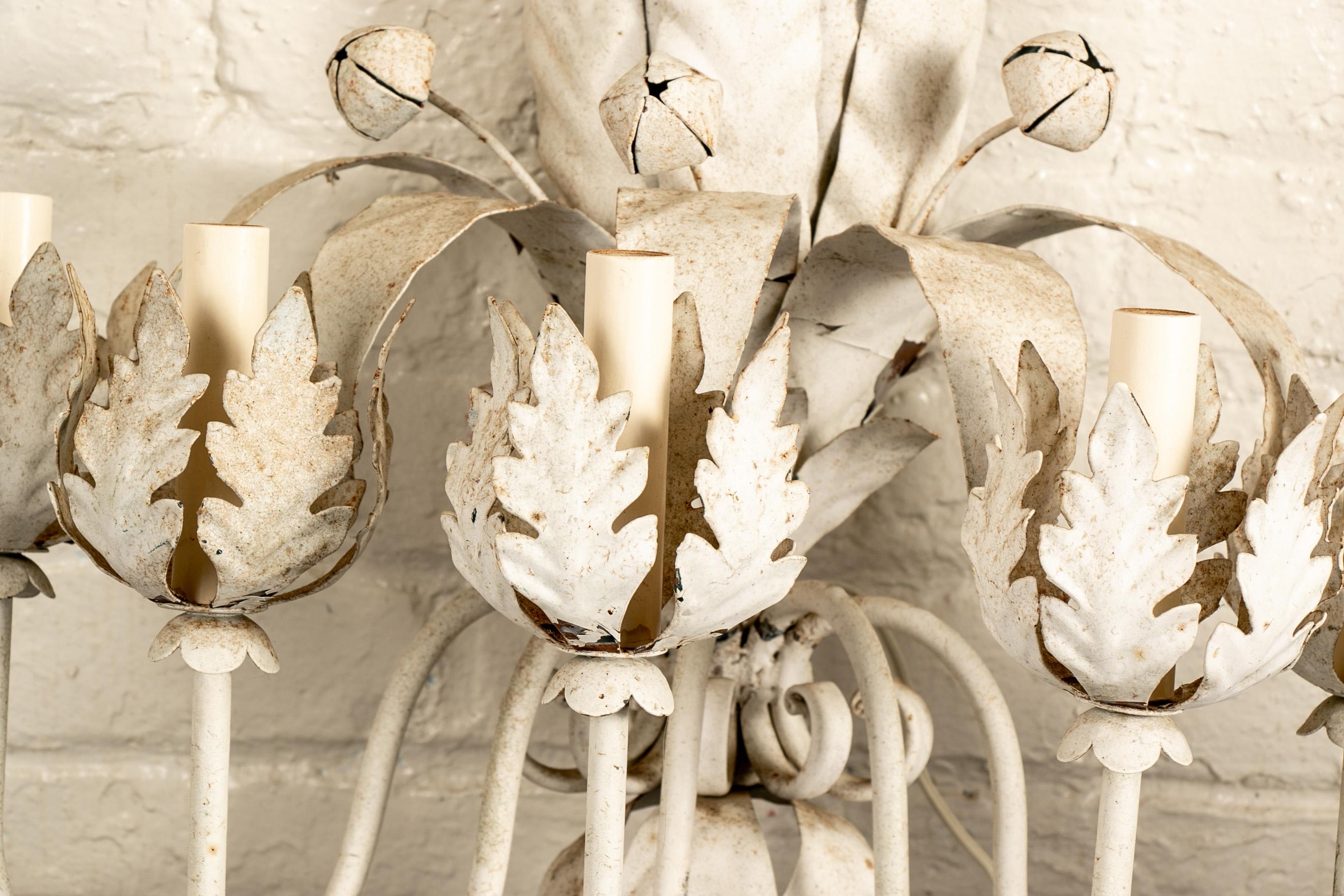 Pair of vintage Italianate white painted metal electric candle sconces, with elaborate layers of leafy supports with an upper tier with projecting buds, and five scrolled arms with leafy 