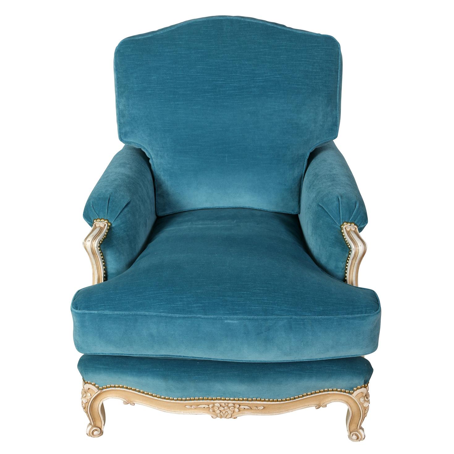 A pair of vintage Jansen style newly upholstered velvet chairs. The pair of bergeres in Louis XV style feature sumptuous cerulean blue velvet upholstery and carved and painted frames. The generous dimensions of the chairs offer comfort as well as