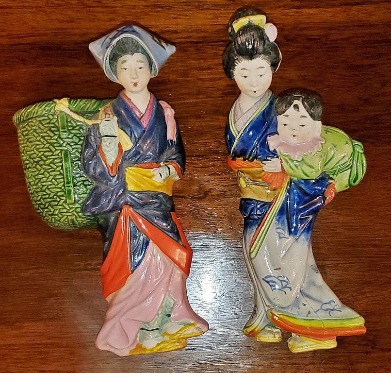 Presenting a gorgeous pair of vintage Japanese porcelain geisha wall pockets.

Mid-20th century, circa 1960.

The pocket on the left depicts a Japanese Farm Girl with a green woven basket slung over her right shoulder. The basket is for holding