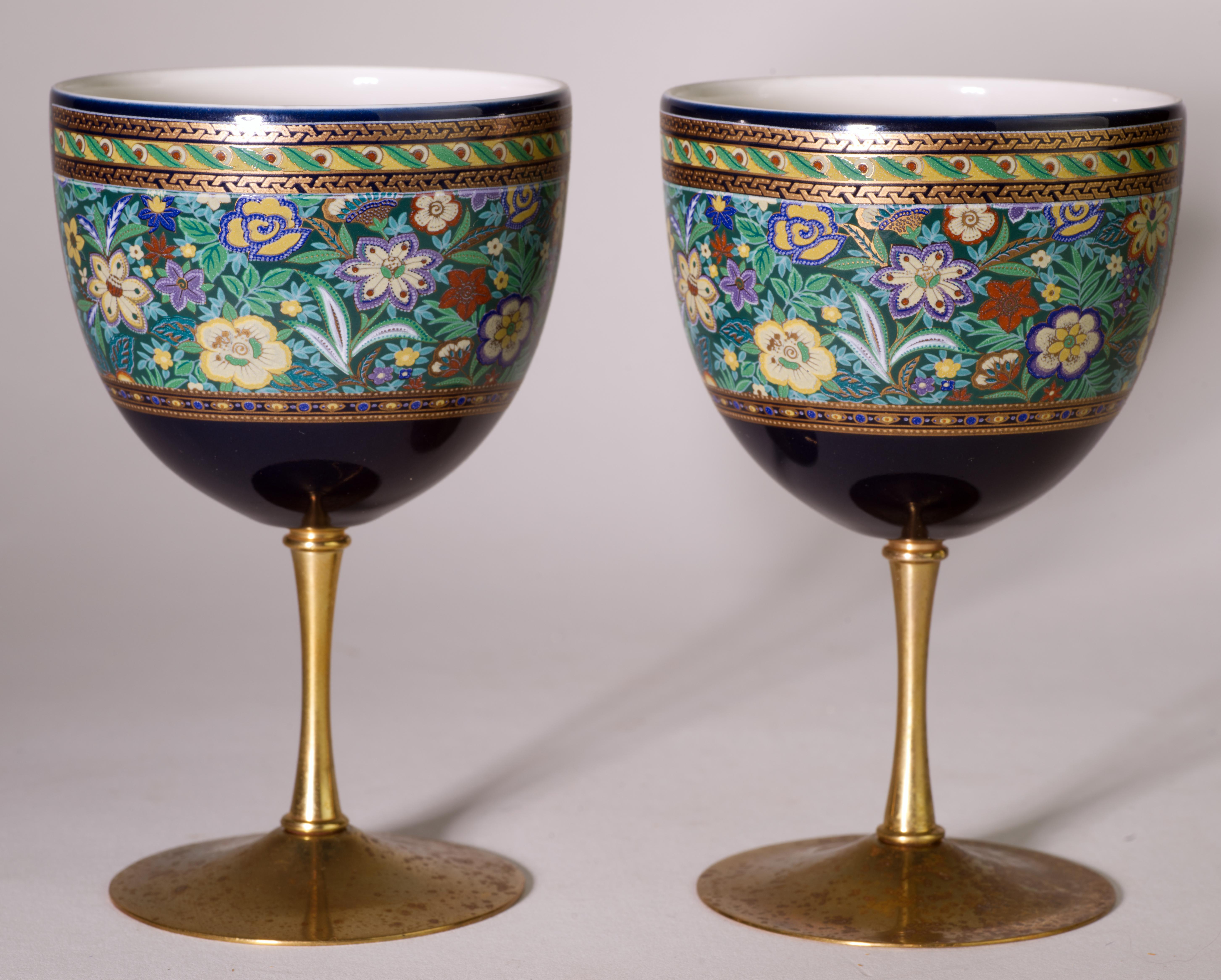  Vintage Kutani porcelain glasses with brass stems are decorated with wide bands of traditional abstract flower motifs on dark blue background. Gold accents in the decor harmonize with the brass, unifying the design and guiding the eye along the