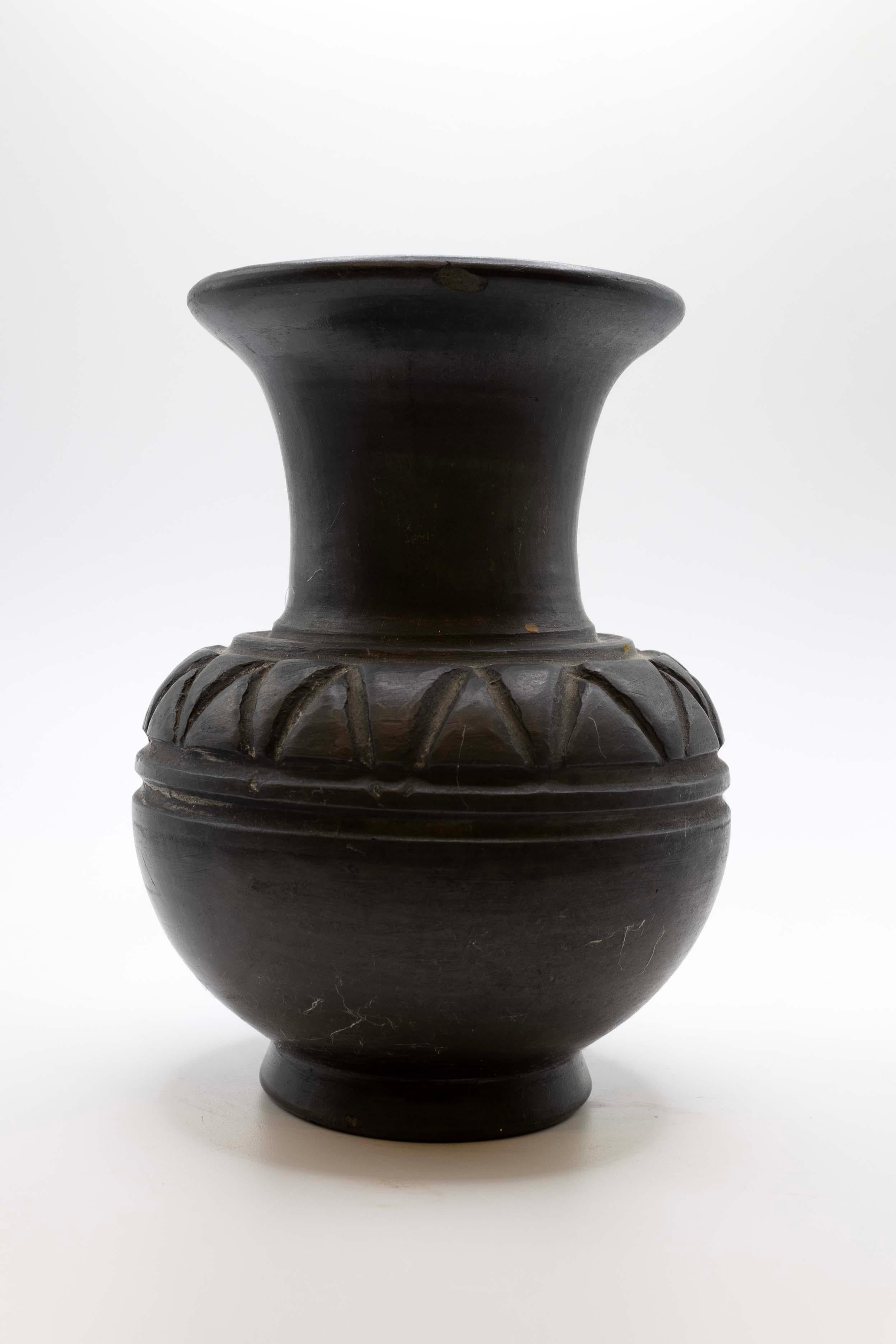 A traditional pair of vintage Lama Oaxaca pottery vase or vessels made from “barro negro” (black clay) from Mexico. Each vessel has unique hand-carved geometric details. Barro negro is one of several pottery traditions in the state. Barro negro is