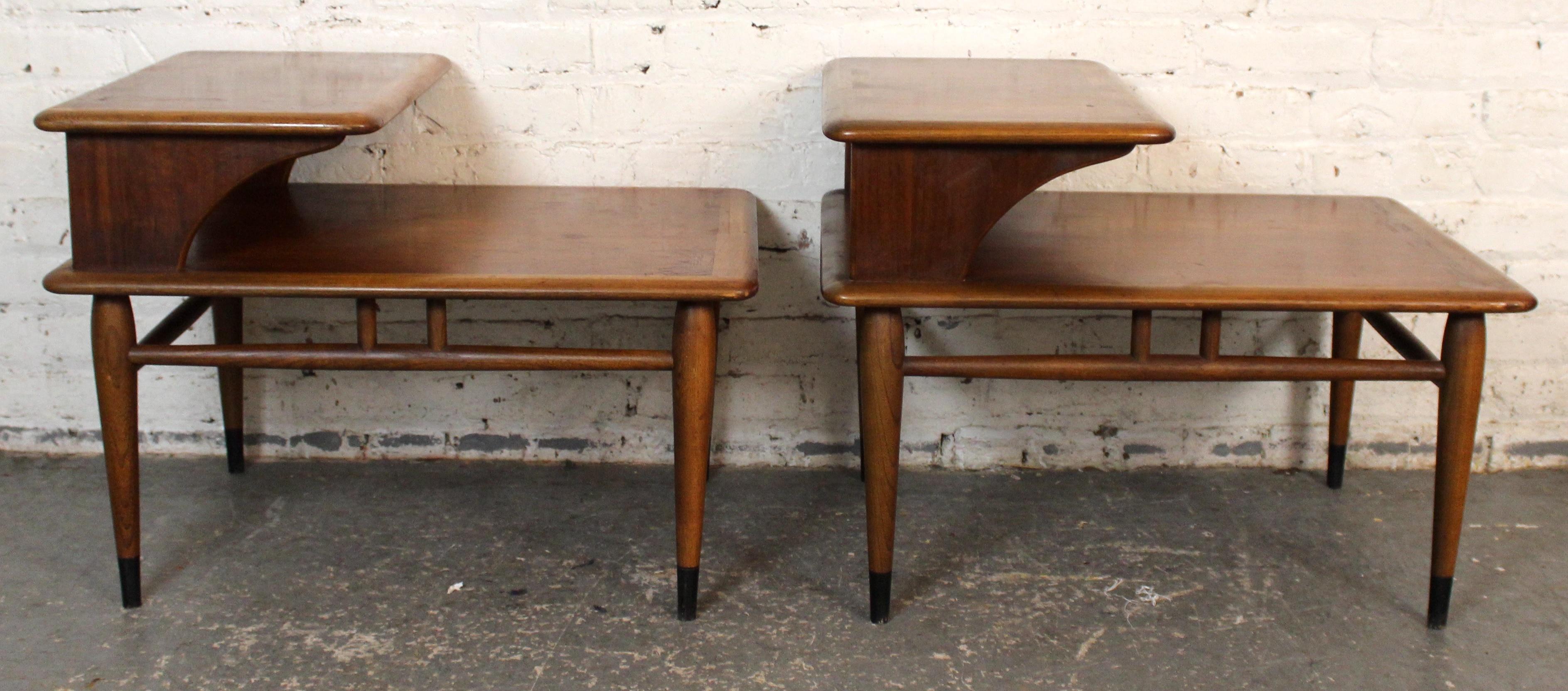 A striking pair of vintage two-tier end tables from the iconic Acclaim series by Lane Furniture. Designed in the 1960s, these tables feature sculptural walnut frames with bold dovetail inlays in contrasting oak, showcasing Lane’s signature