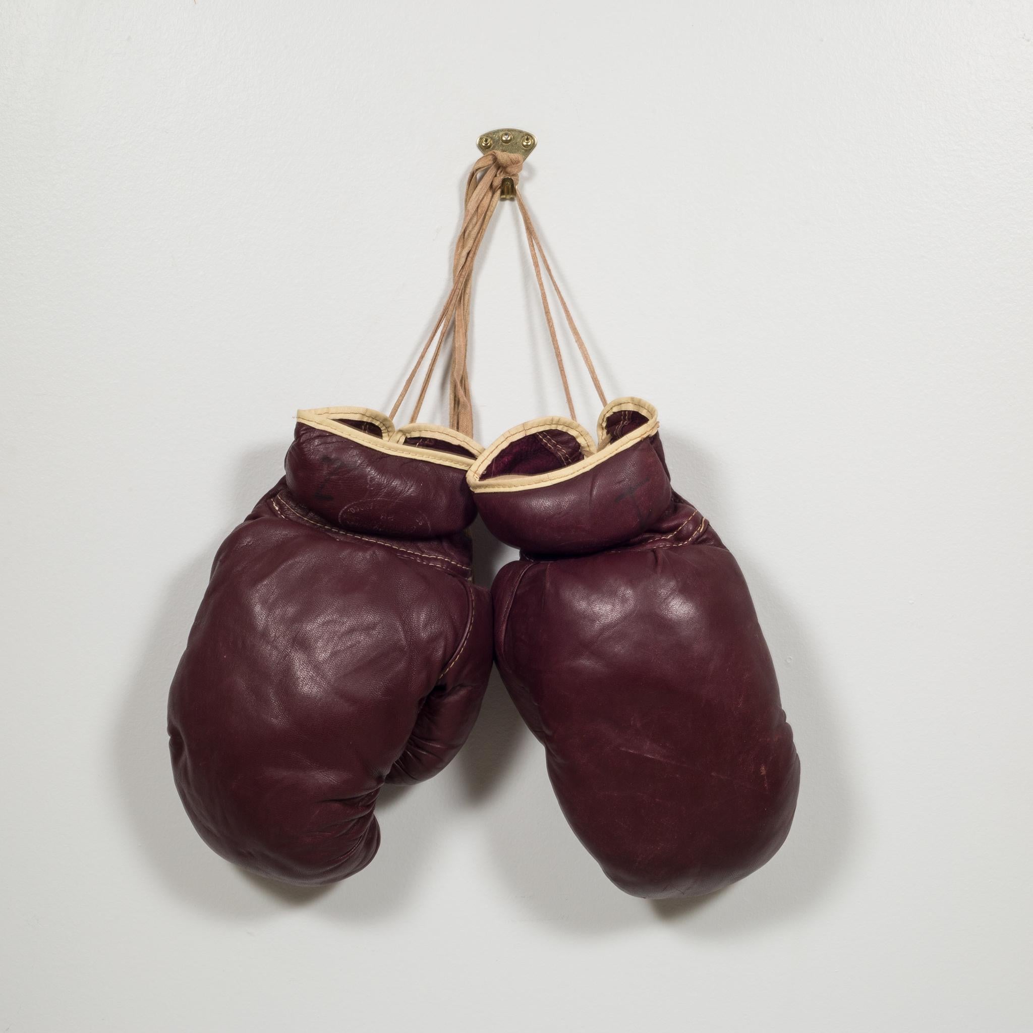 About
This is an authentic boxing gloves with reddish, brown leather. Each glove has tan leather piping and laces. The leather is very soft and is good condition. Stamped J.C. Higgins label on each glove but is very faded. 

Creator J.C. Higgins,