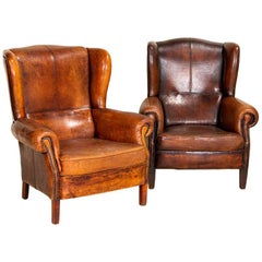 Paire de vieux fauteuils club en cuir