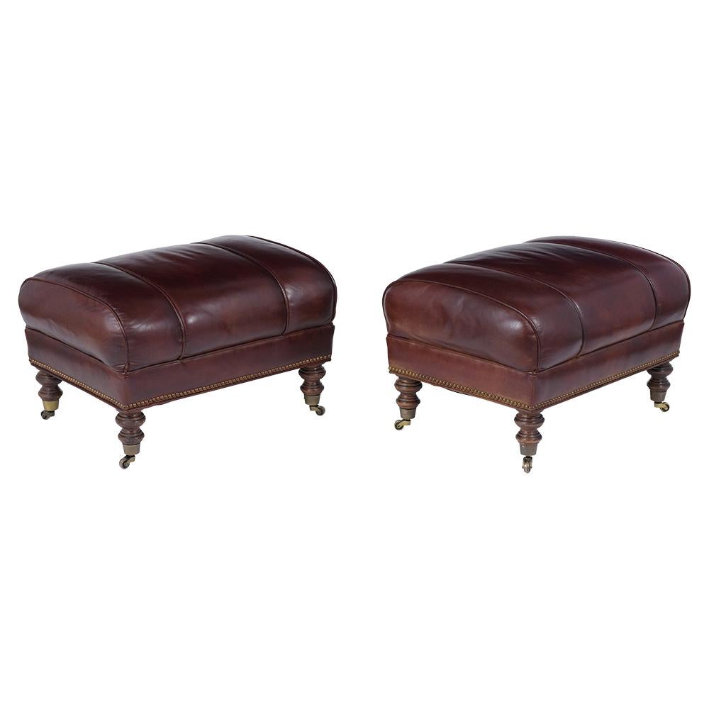 A Wonderful Pair of Vintage Chesterfield style Ottomans made out of solid wood and features its original leather upholstery newly dyed in a dark brown color with a beautiful patina finish. This set sits on four carved legs with original brass caster