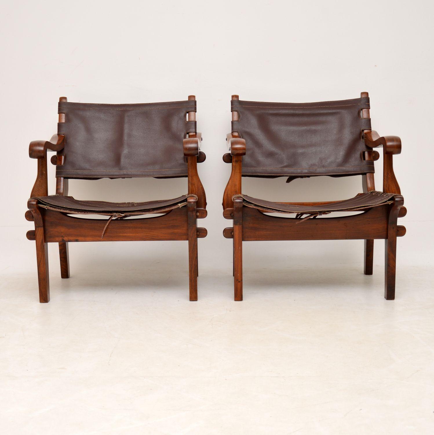 A stunning and rare pair of vintage safari chairs in solid rosewood and leather, these were made in Equador in the 1960s, they were designed by Angel Pazmino. They are in excellent vintage condition, the frames are all clean, sturdy and sound, with