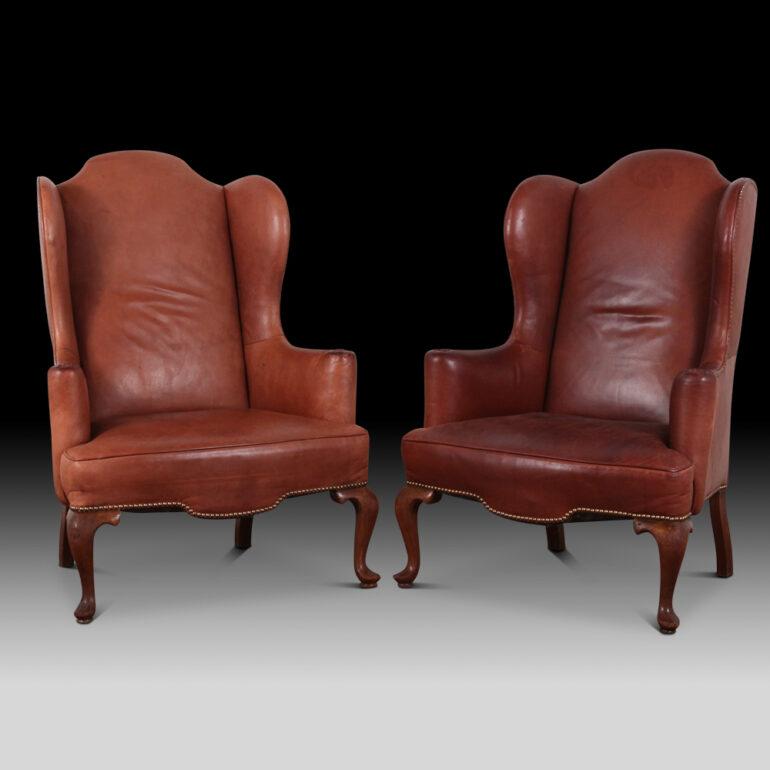 Very comfortable pair of English leather wing back chairs. High quality leather with stud detailing and wooden legs. These classic chairs are always a great addition to any living space.

