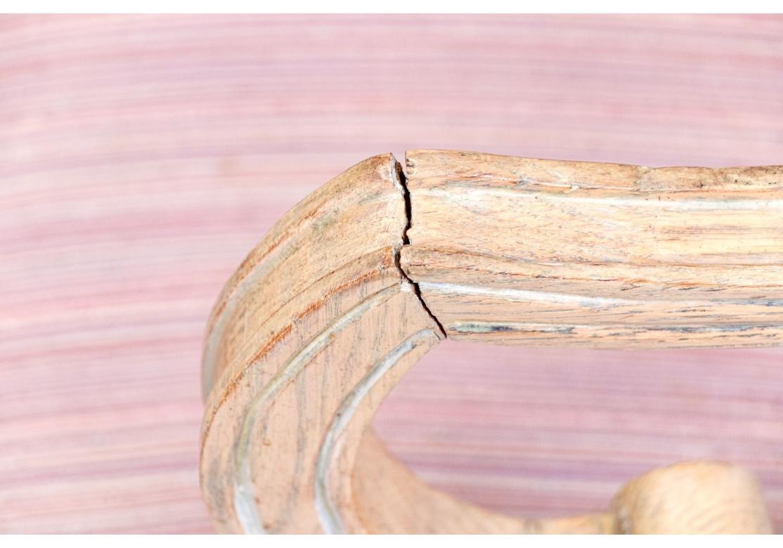 Ein Paar Sessel im Stil Louis XV mit charakteristischen geschwungenen Linien, einem hellen (weiß getünchten oder naturbelassenen) Holzrahmen mit kunstvollen Schnitzereien, einer runden oder tonnenförmigen Rückenlehne und einer offenen, fließenden