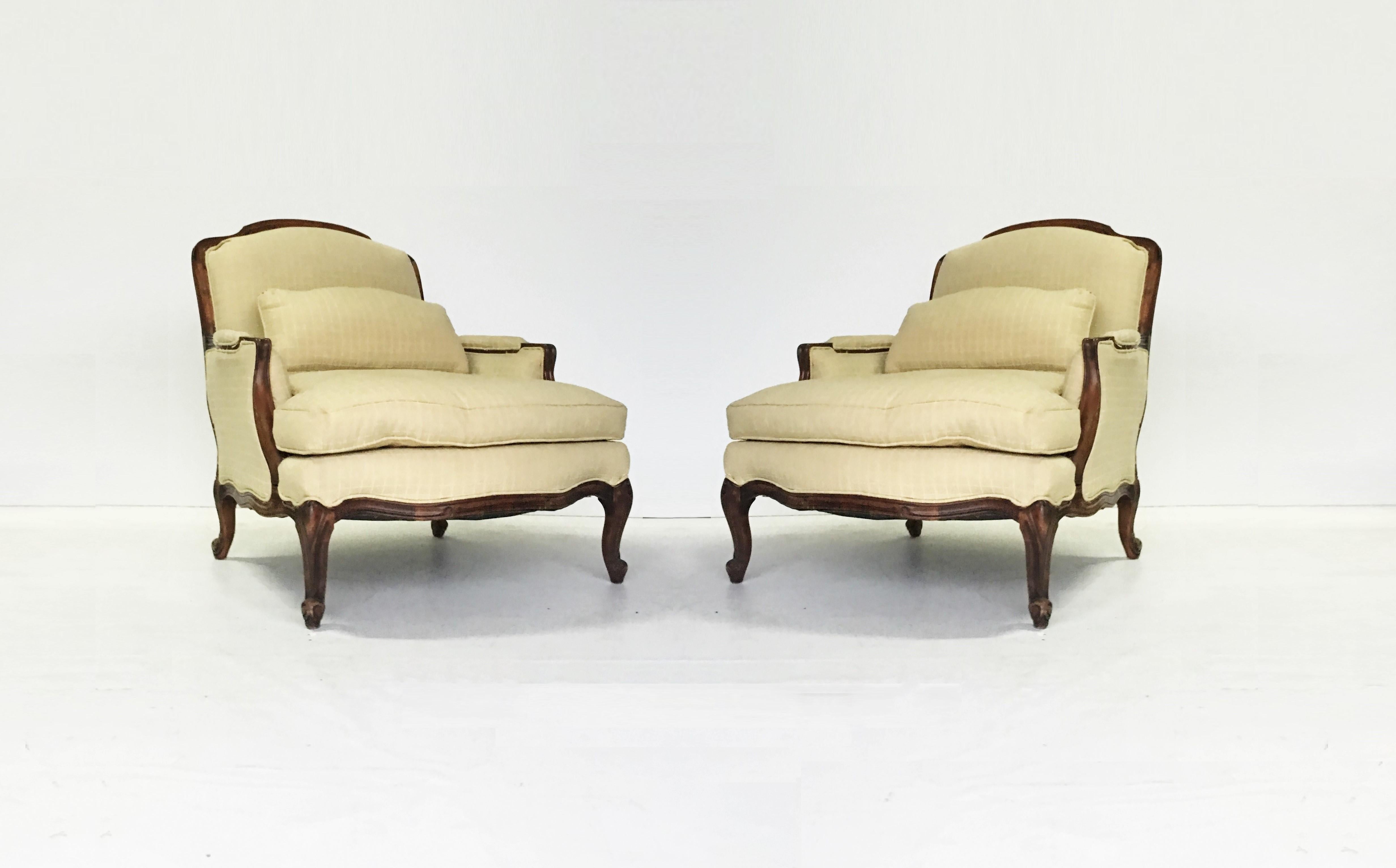 Wonderful pair of Louis XV style bergère chair and ottoman set. Featuring wide upholstered frames, with padded scroll arms on classic cabriole legs headed by carved floral motif. Can be used as is but upholstery is recommended.
Chair size 36 in H x